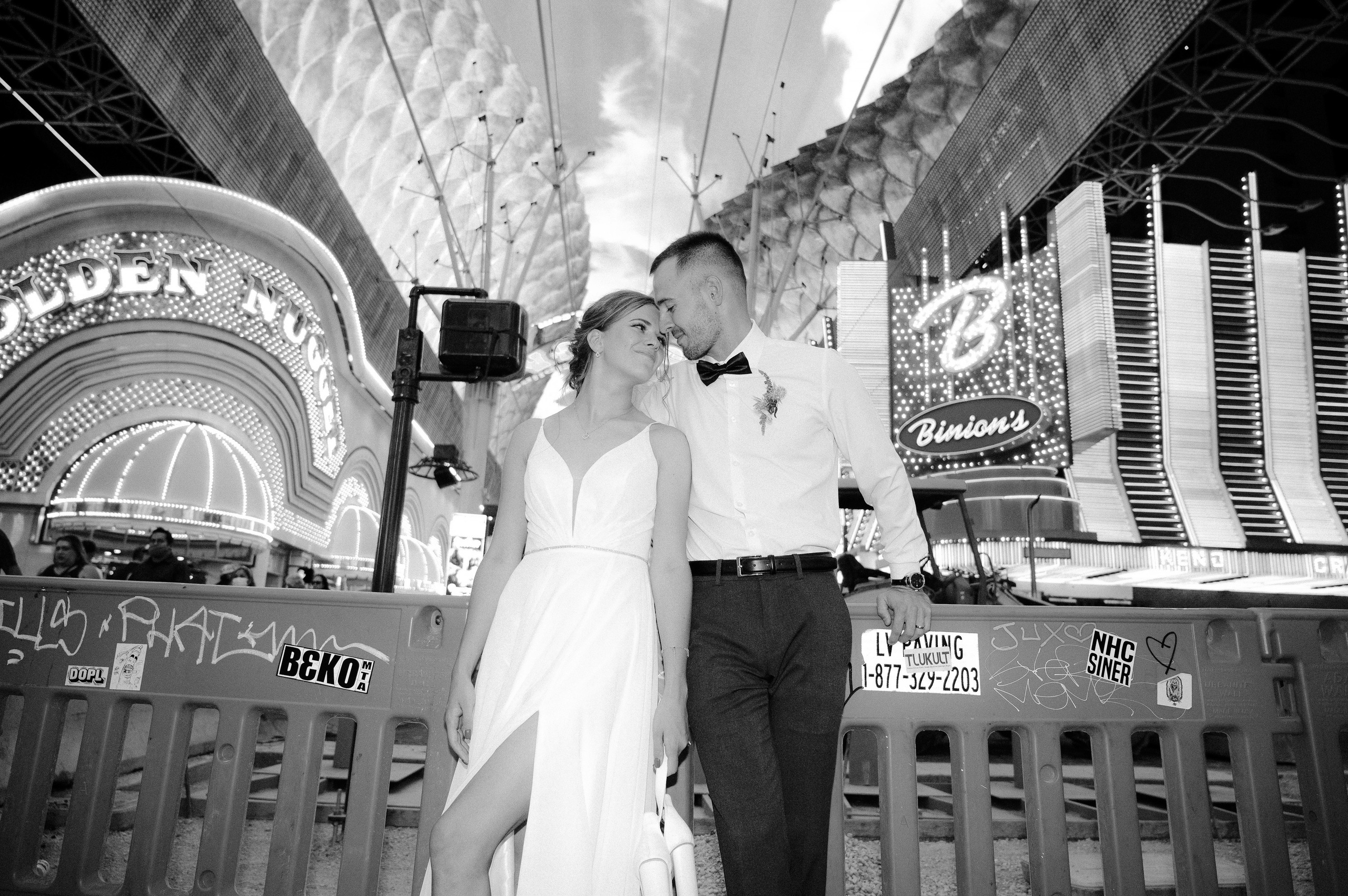 a couple is posing for a photo in front of a large sign