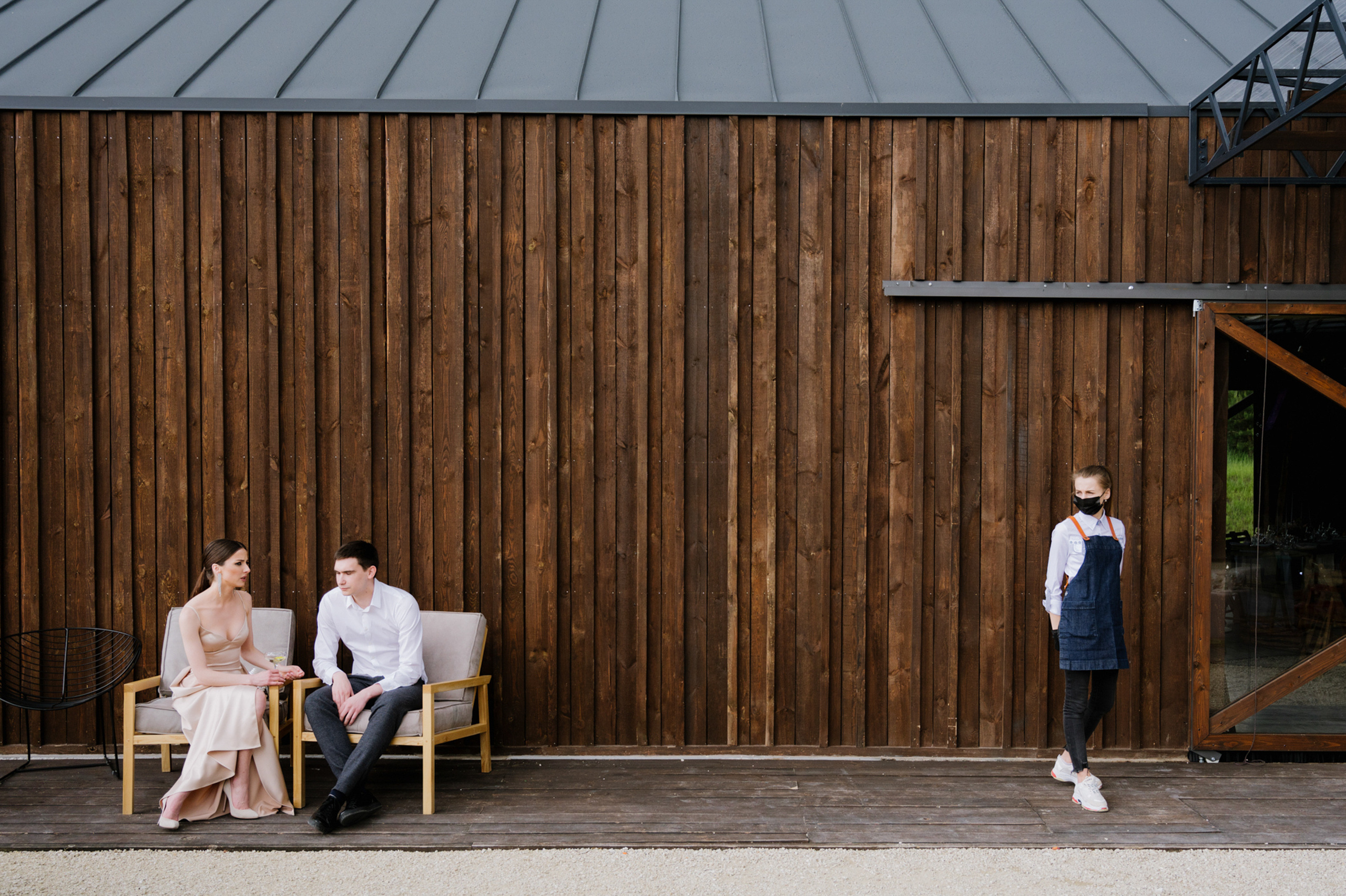 a couple sitting on a bench in front of a wooden building