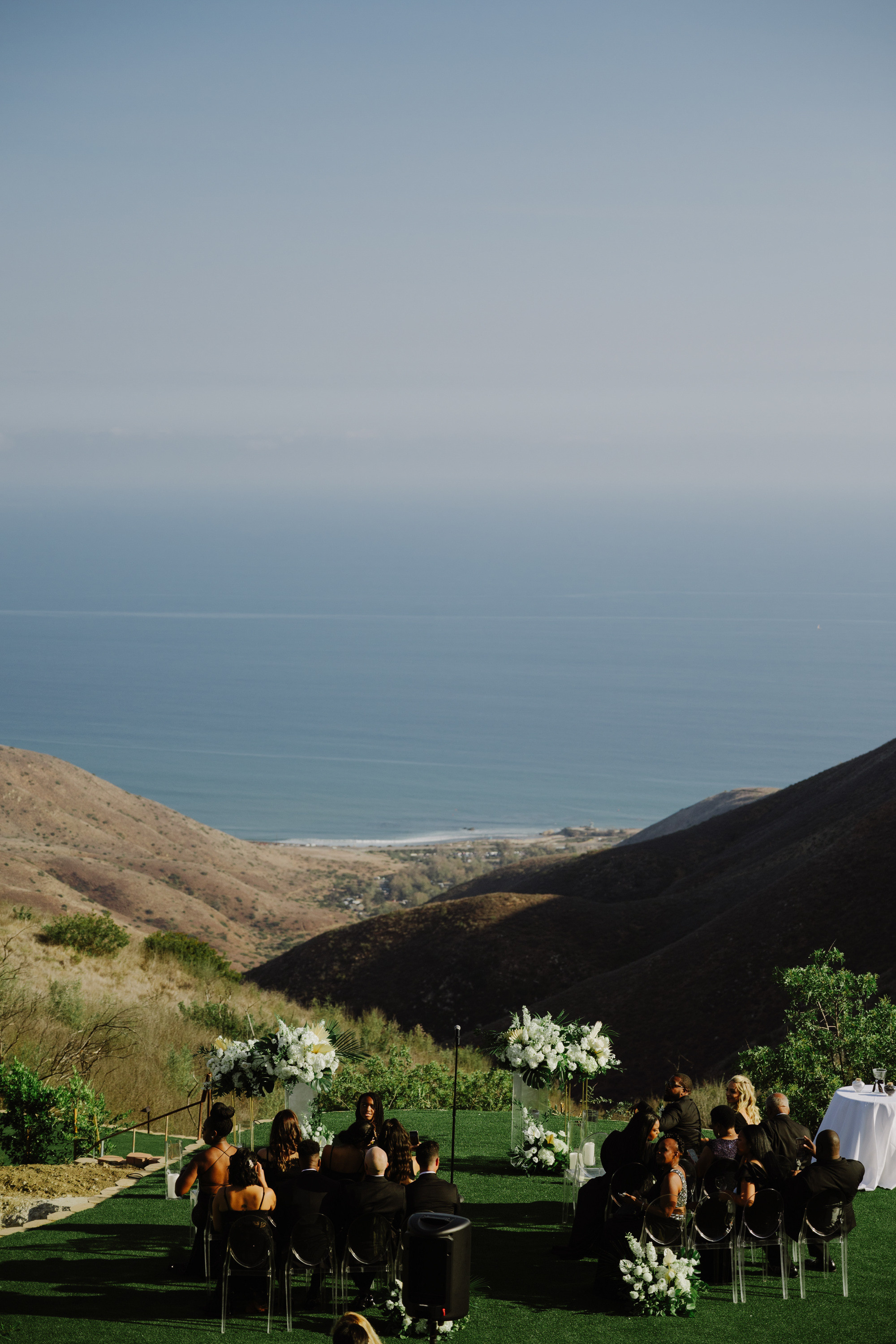 a wedding ceremony on the lawn overlooking the ocean