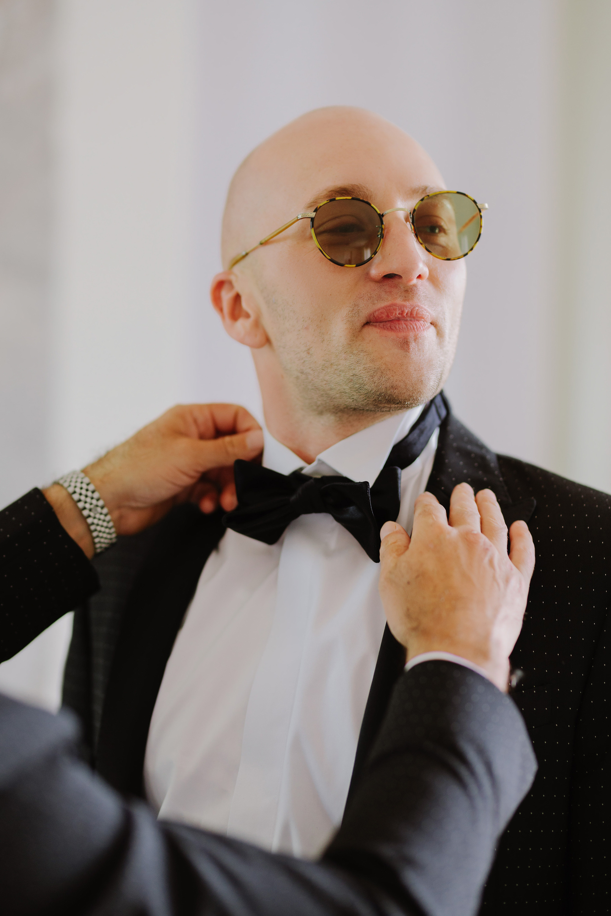 a man in a suit adjusting his tie
