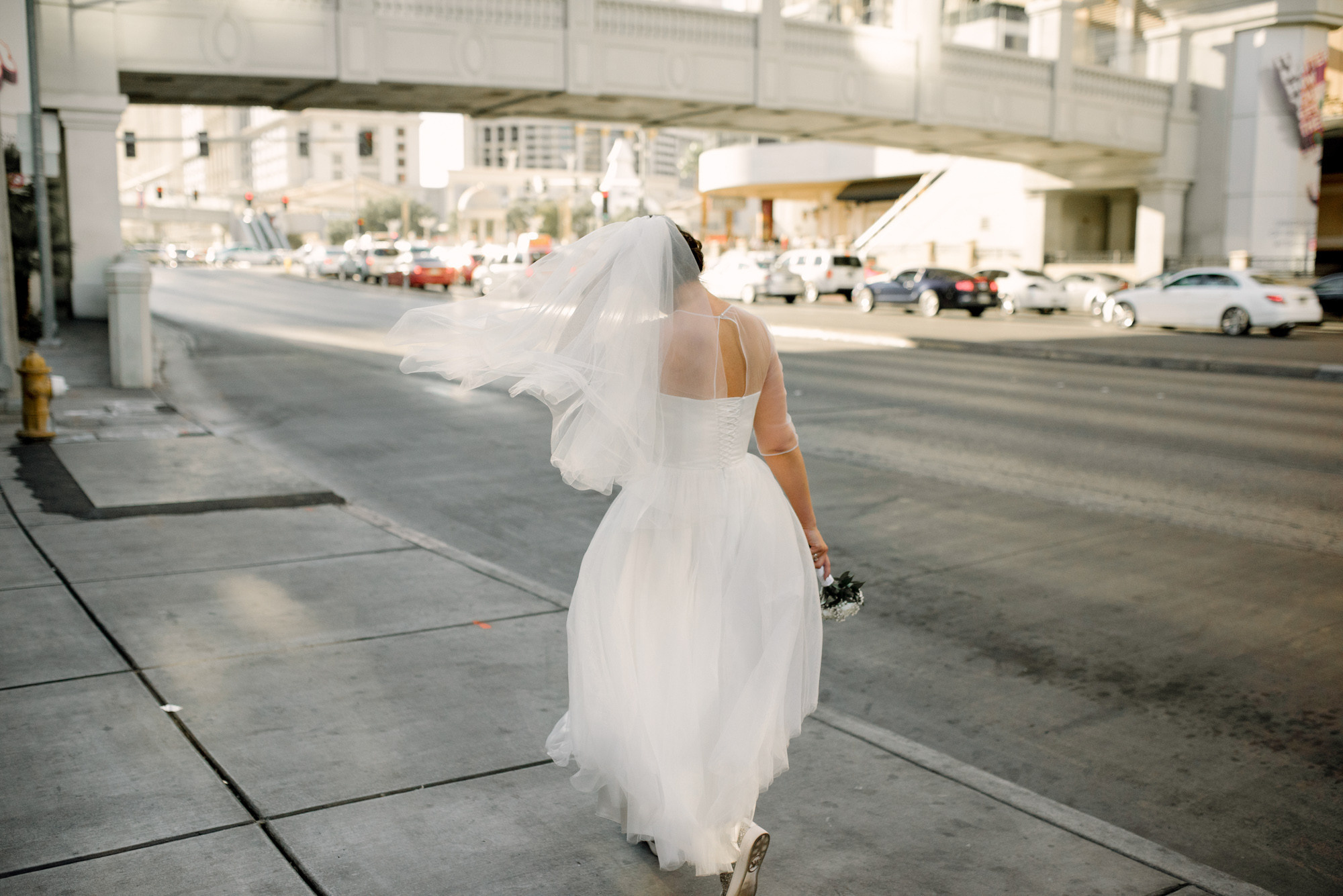 a bride walking down the street in a white dress