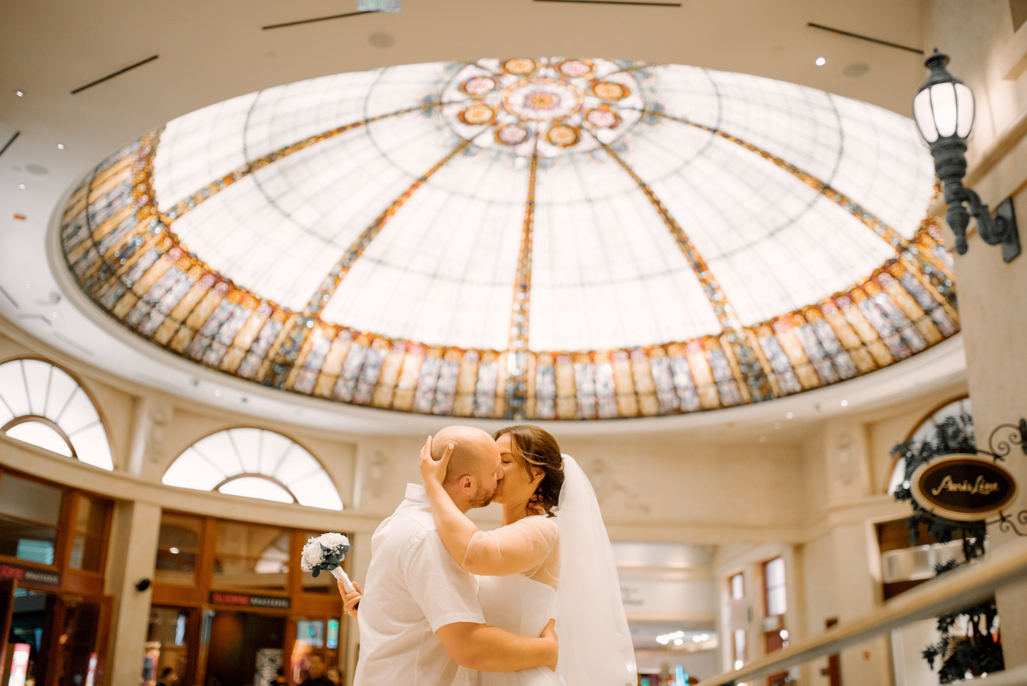 a bride and groom kissing in a hotel lobby