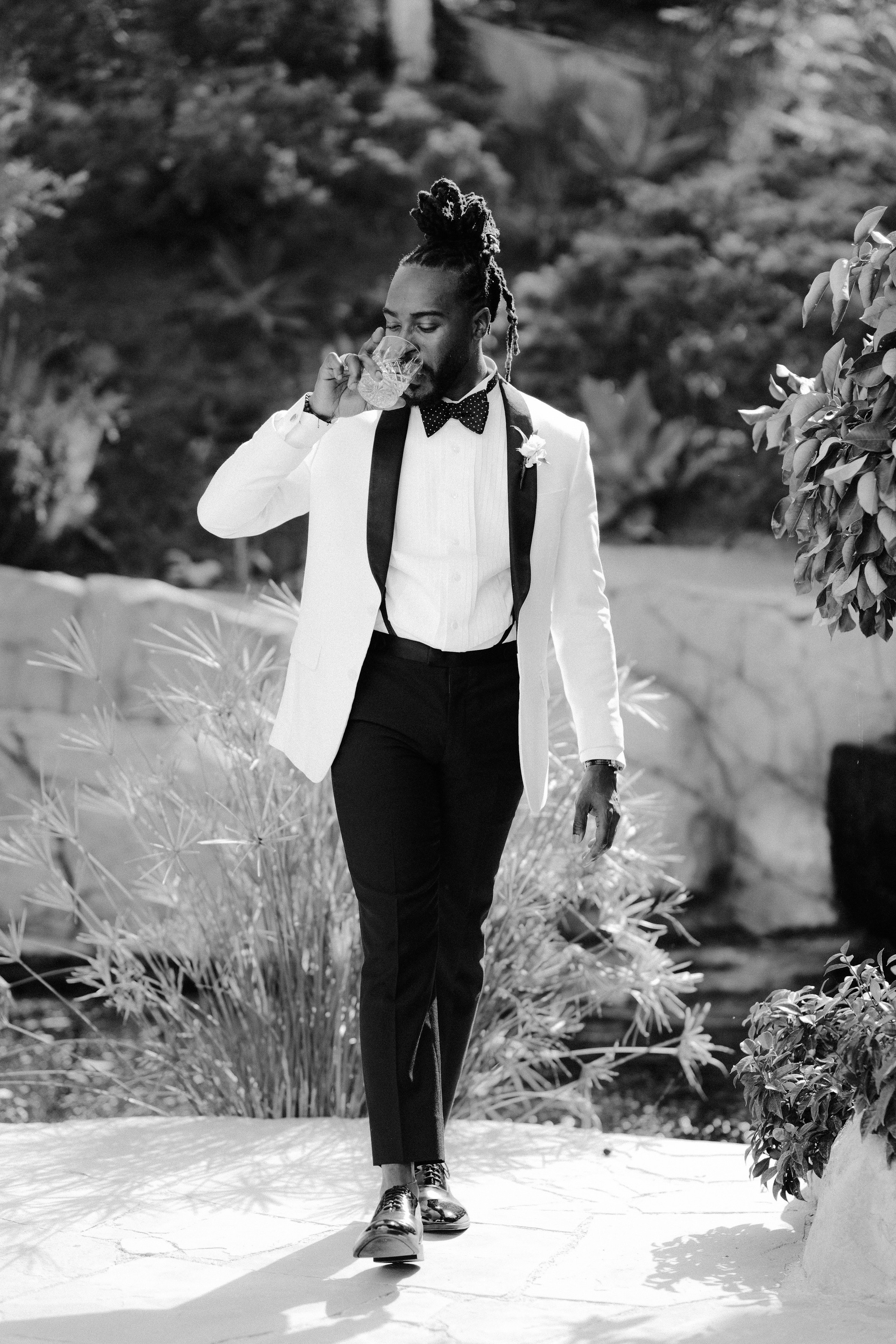 a man in a suit and tie walking down a path