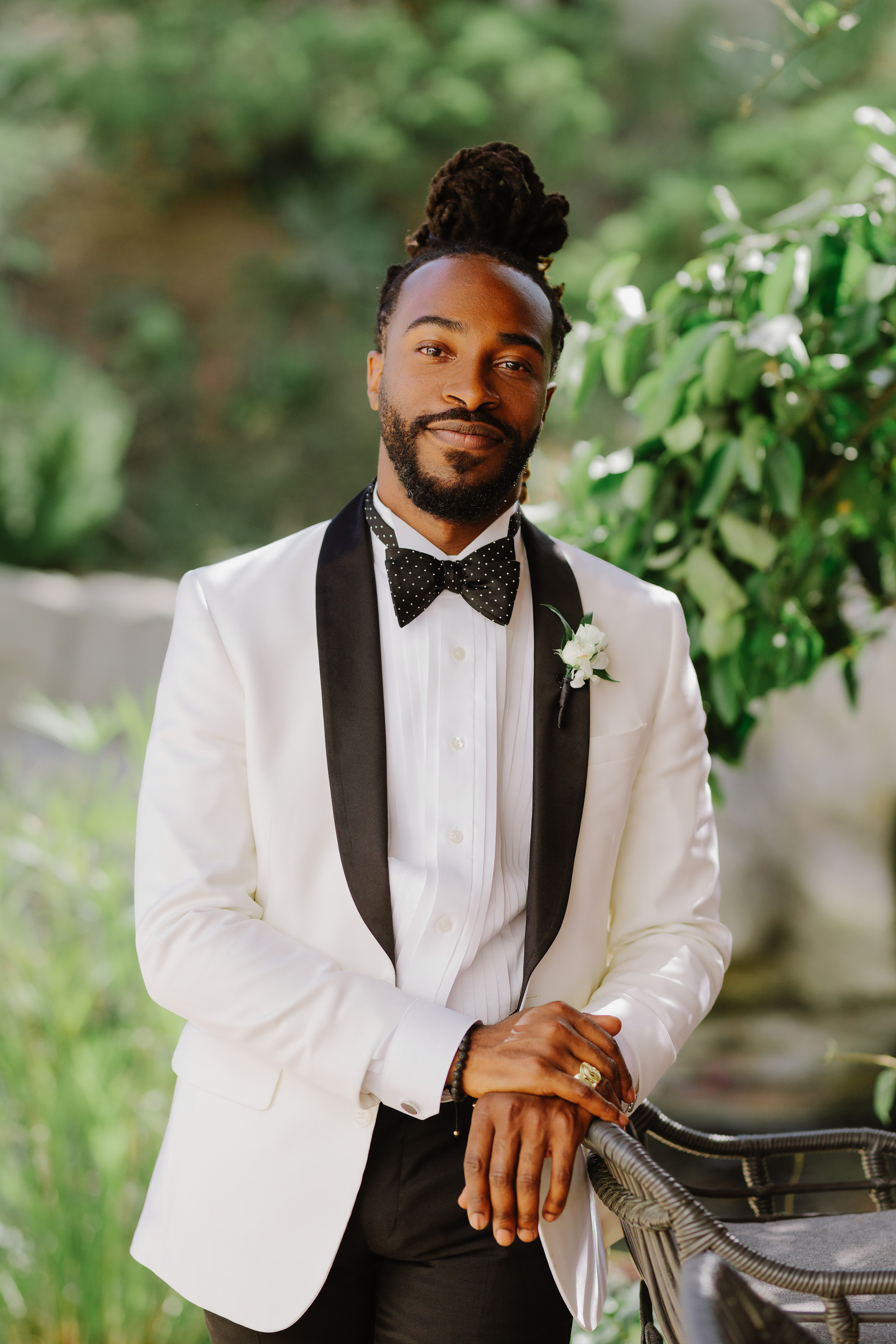 a man in a white suit and bow tie