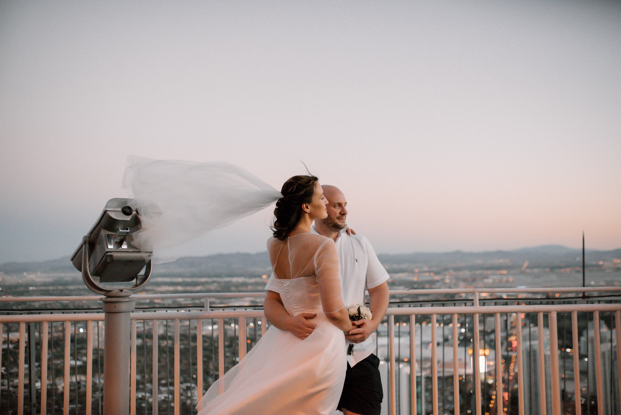 a bride and groom standing on a balcony