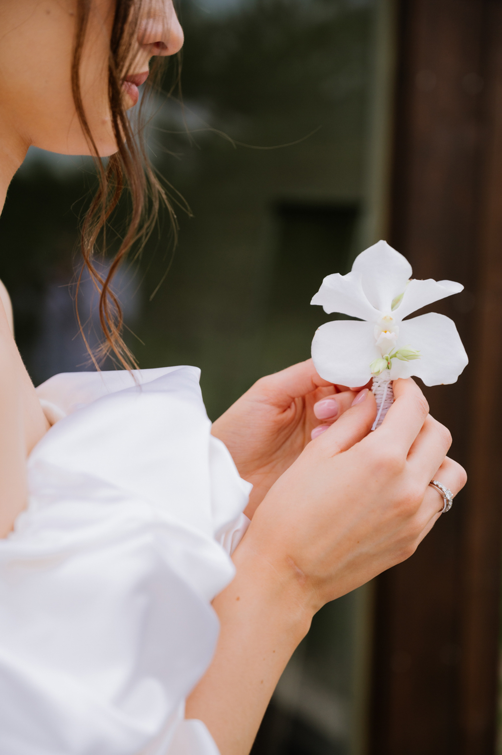 a woman in a white dress holding a flower