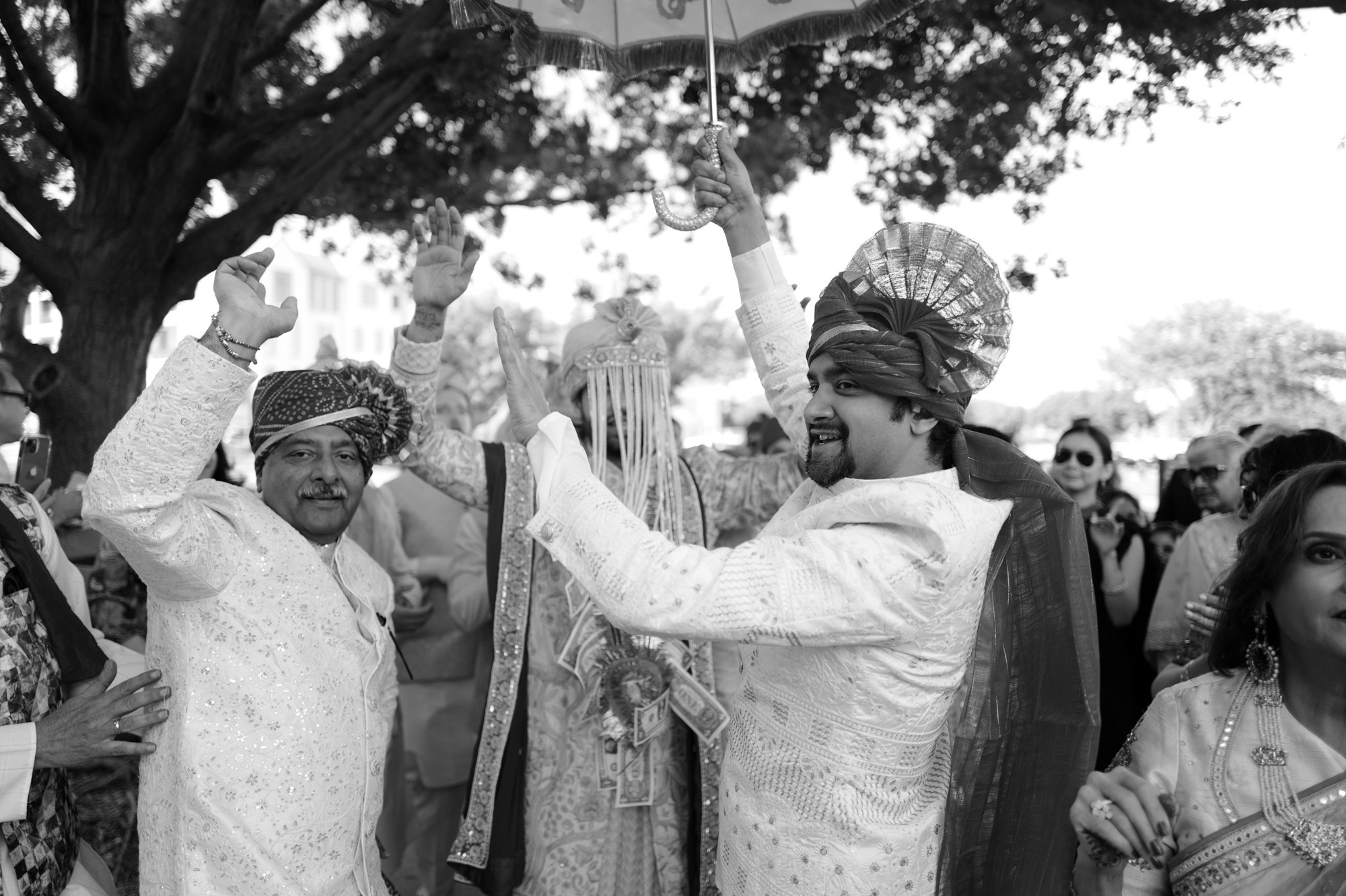 a man and woman in traditional attire holding an umbrella