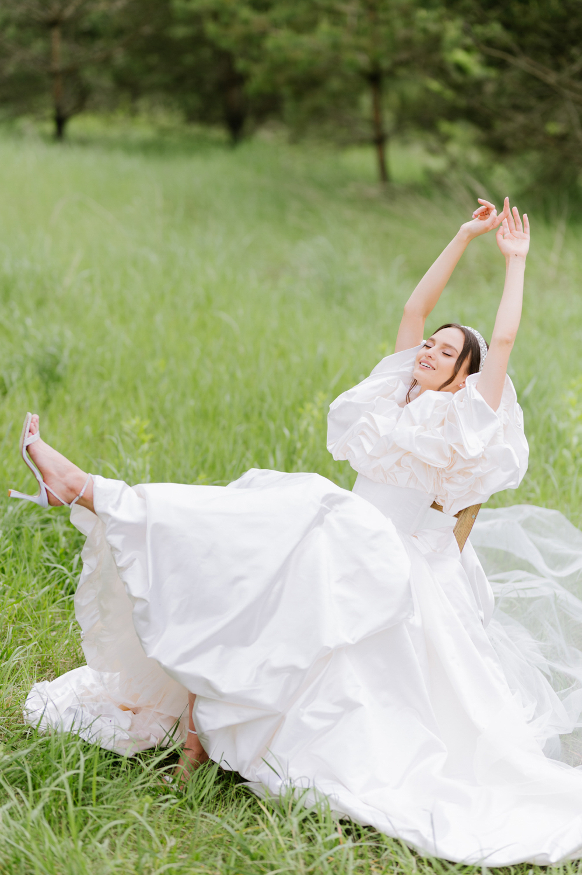 a bride in a white dress is laying on the grass