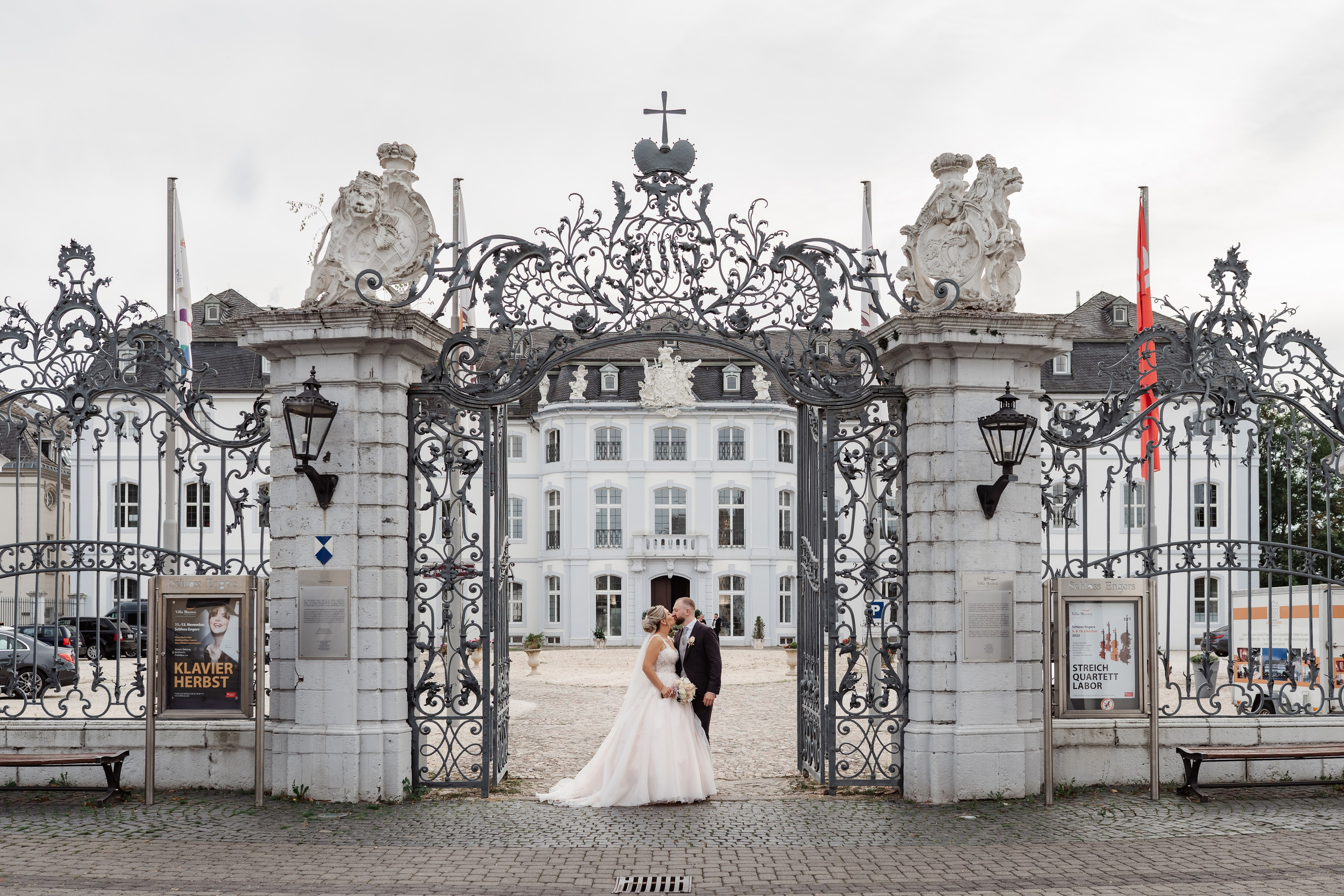 Romantisches Brautpaar vor einem majestätischen Schloss, umgeben von festlicher Atmosphäre
