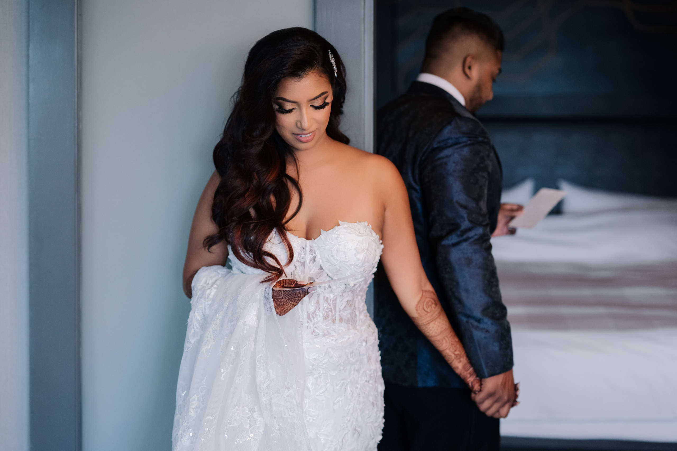 a bride is looking at her phone while she stands in front of the door