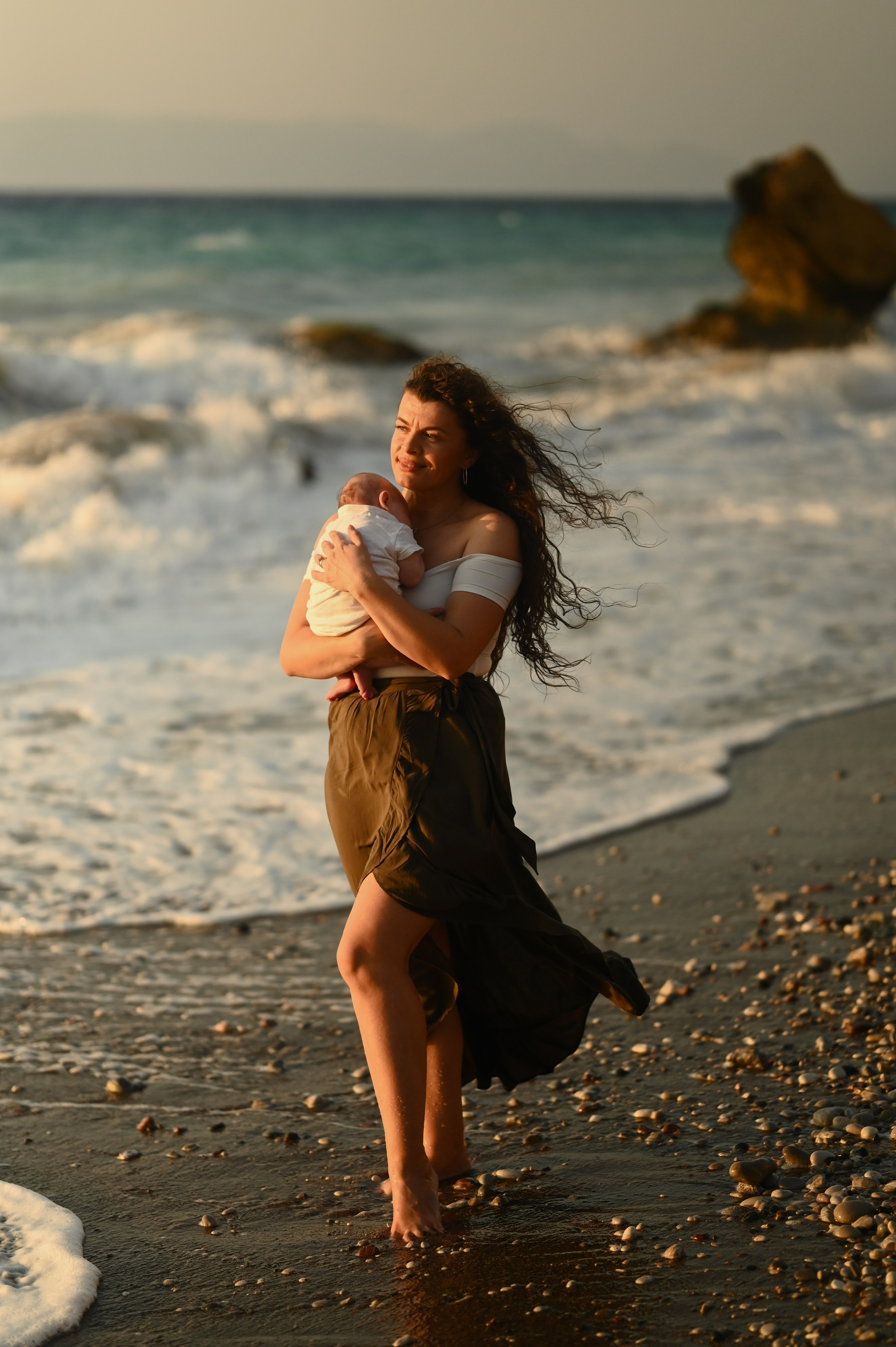 Happy family walking along a Rhodes beach at sunset. Photographer in Rhodes Island