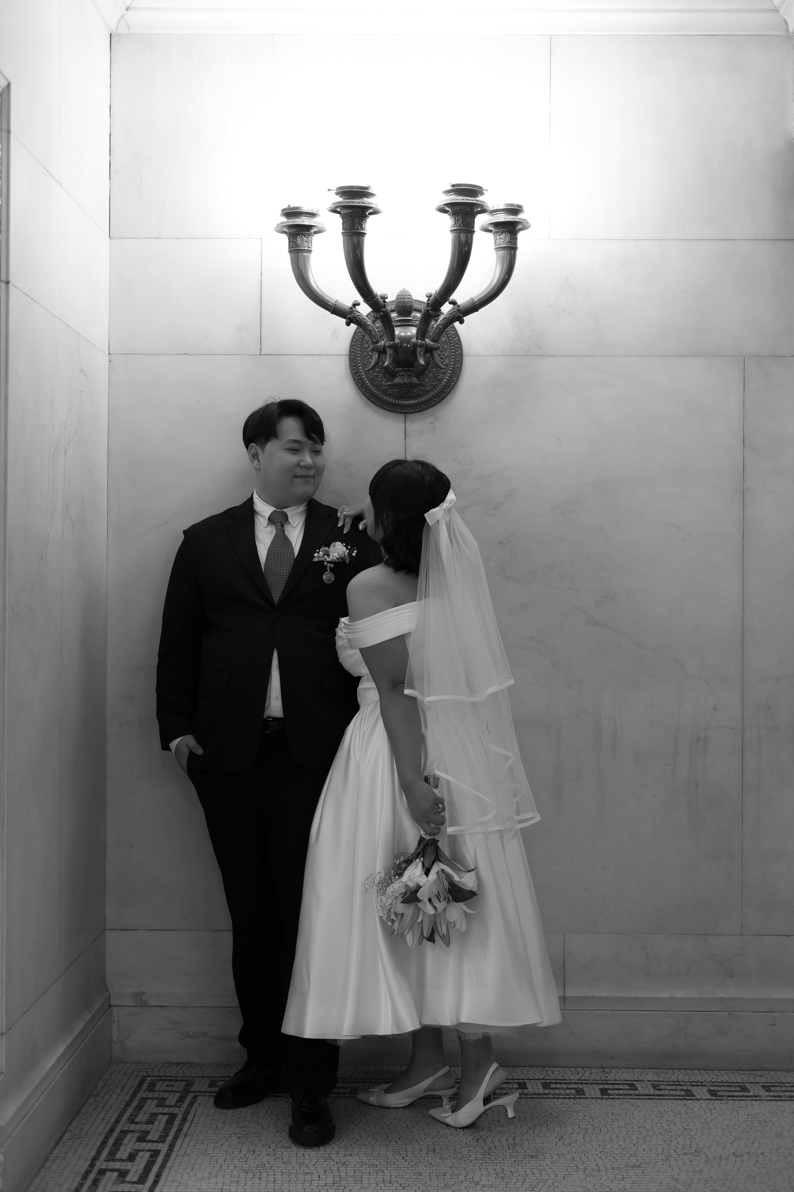 Couple standing under a lamp inside the Chicago Cultural Center, smiling