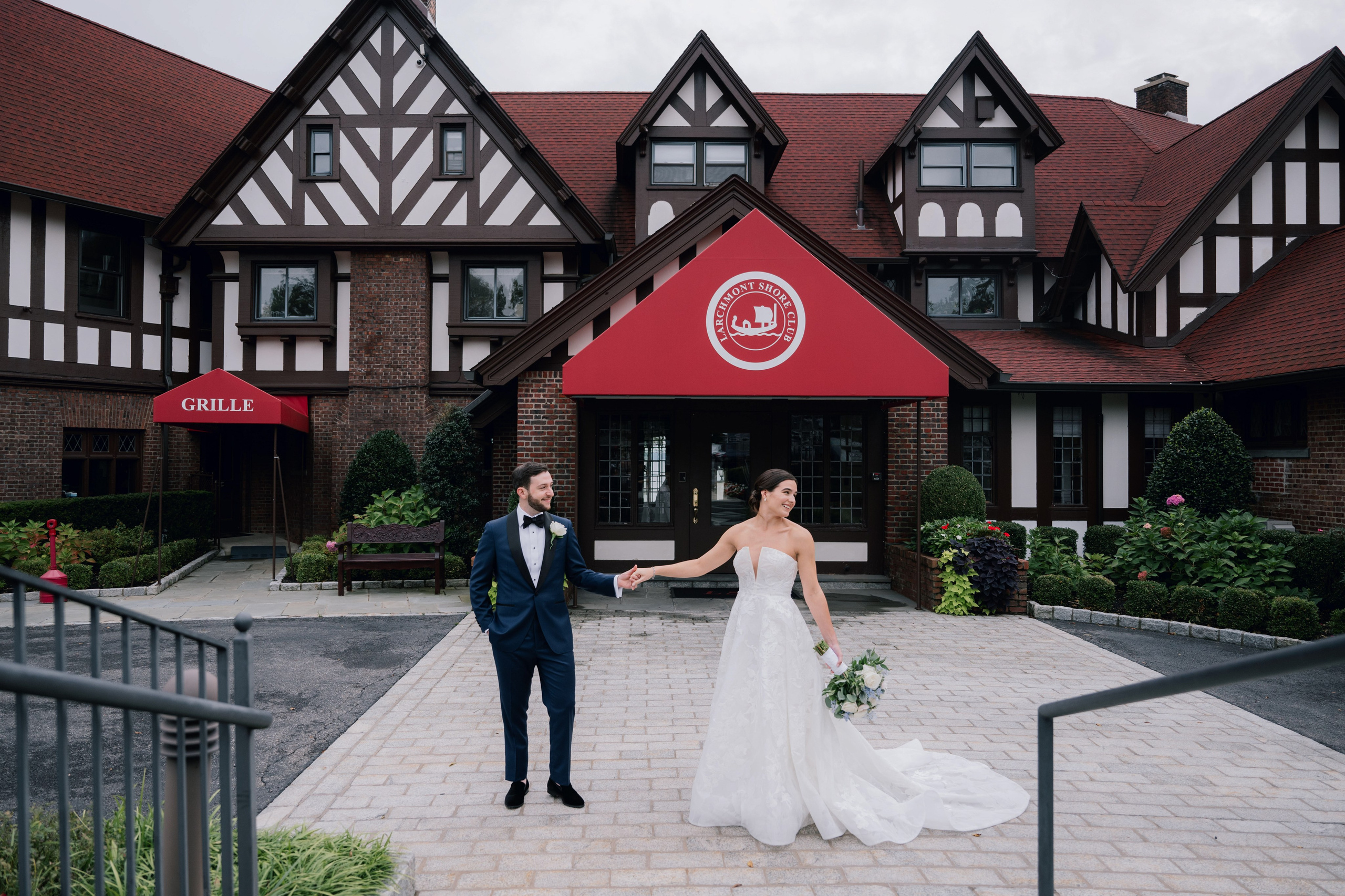 a bride and groom walking in front of a red and white building