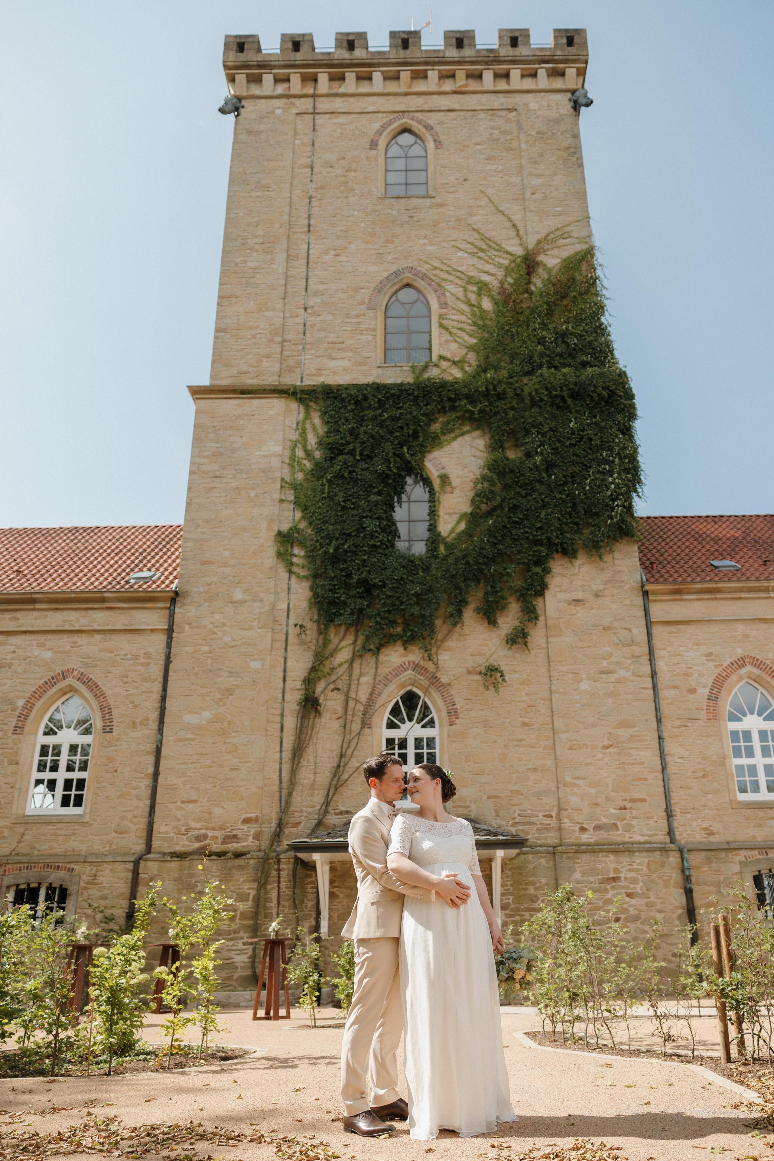 Brautpaar posiert vor dem historischen Turm der Diedrichsburg