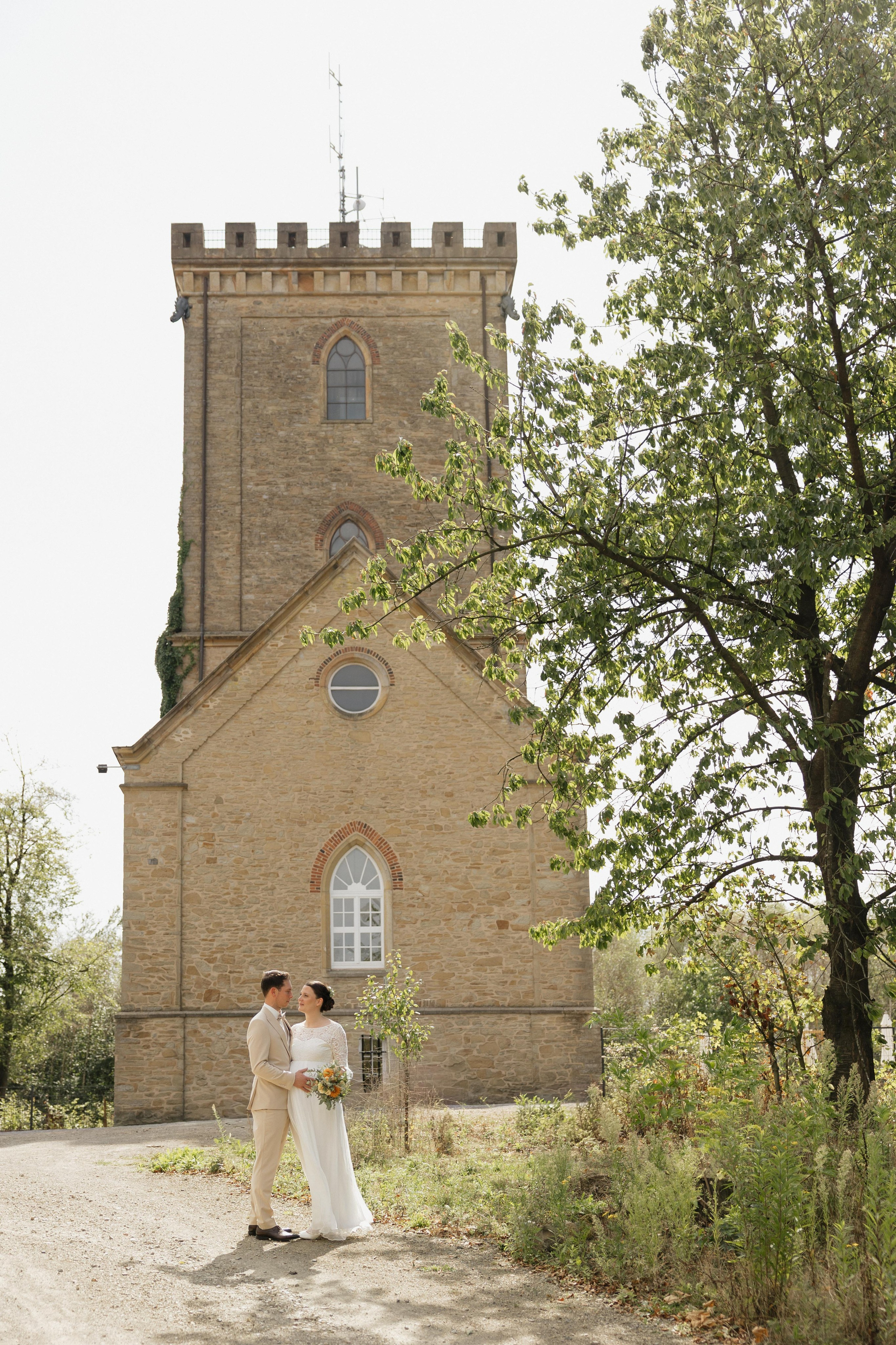 Brautpaar vor dem historischen Turm der Diedrichsburg bei der standesamtlichen Hochzeit