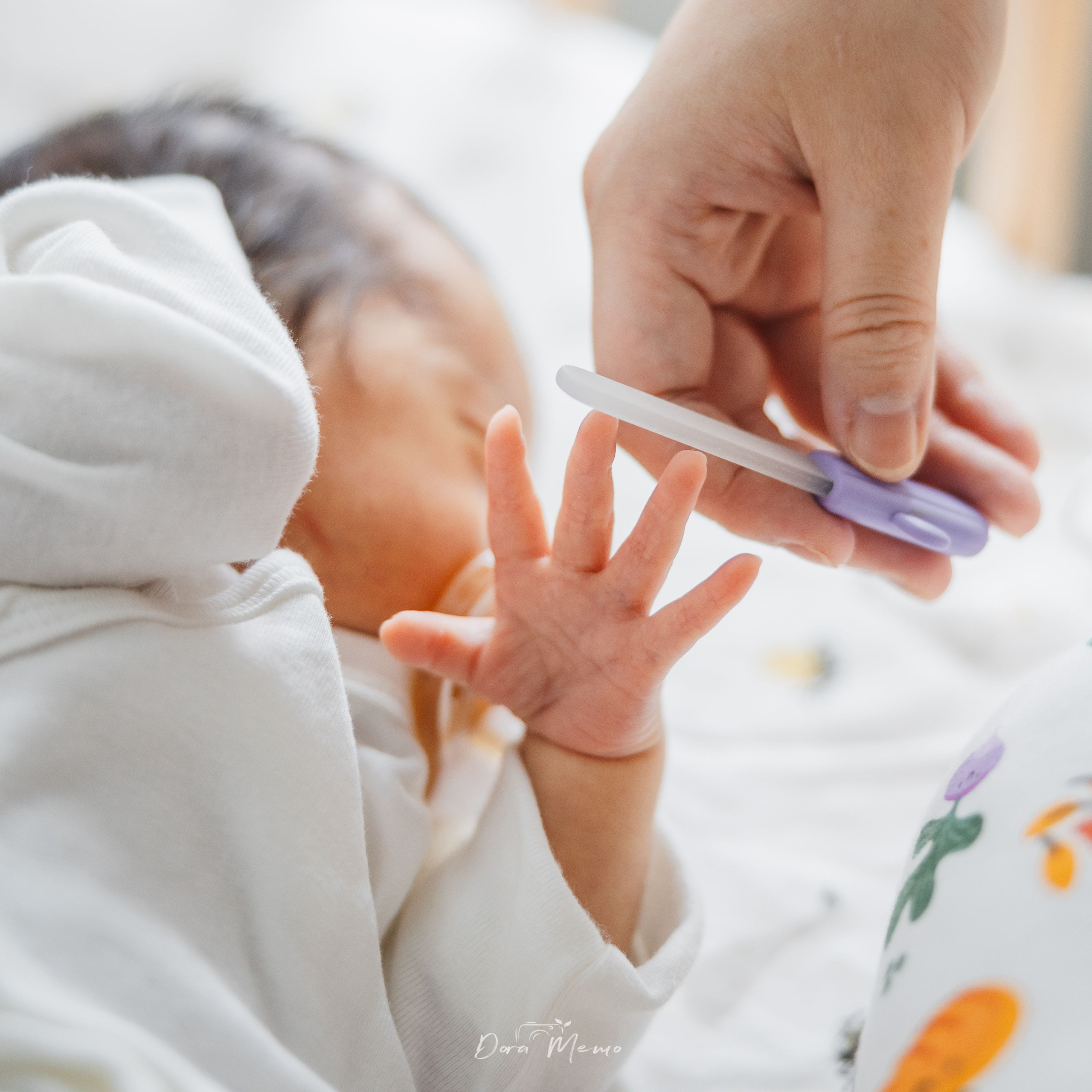 Close-up of a parent carefully trimming a newborn's tiny fingernails, quiet moment of newborn care at home