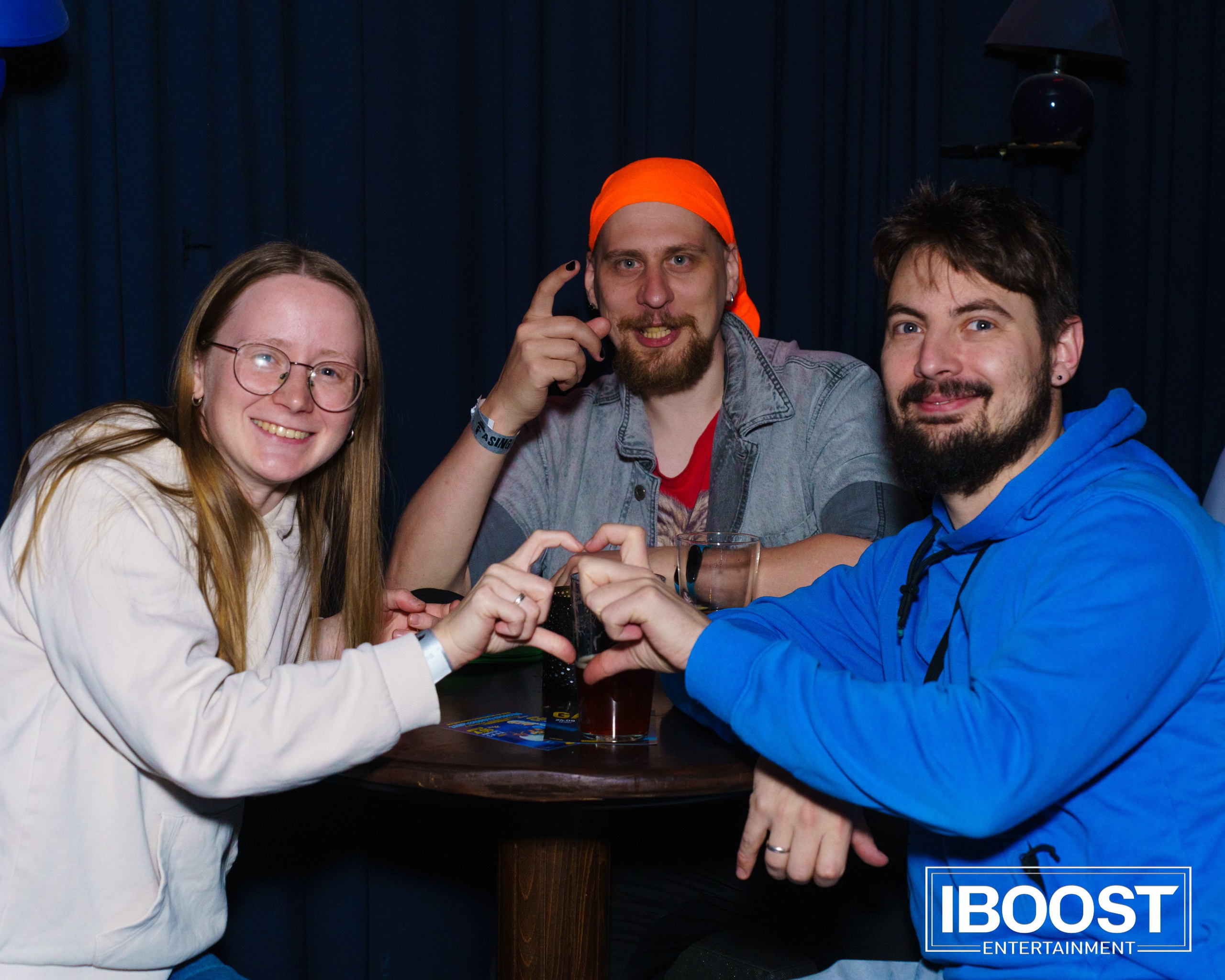 Three friends posing at a table with drinks during the Animal JazZ concert in Sofia.