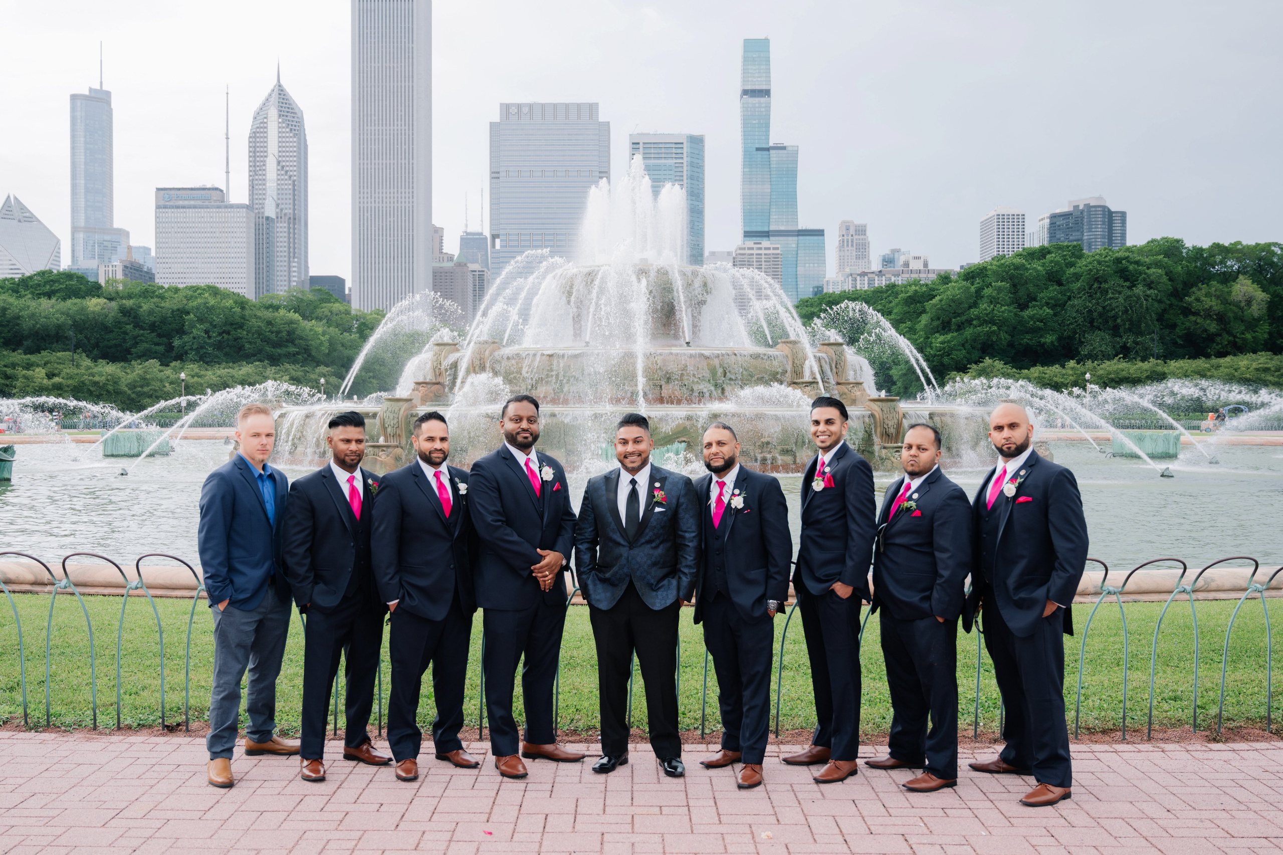 a group of men standing in front of a fountain