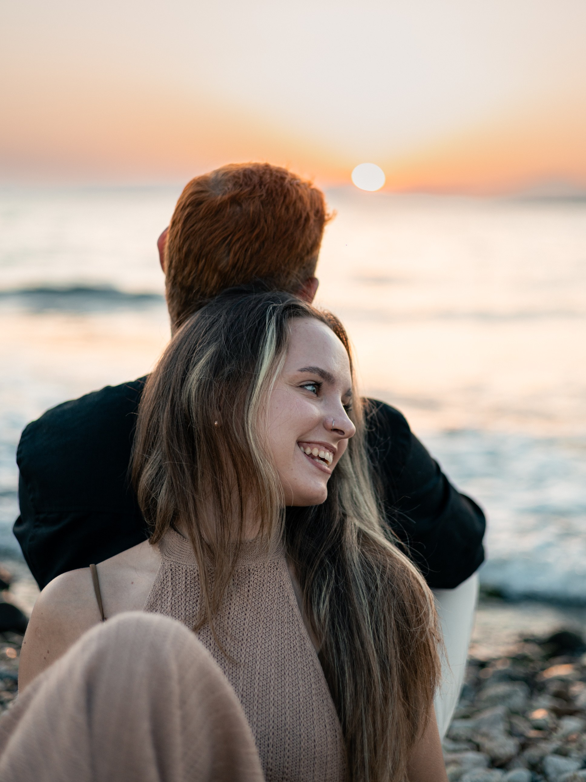 Couple watching the sunset by the sea