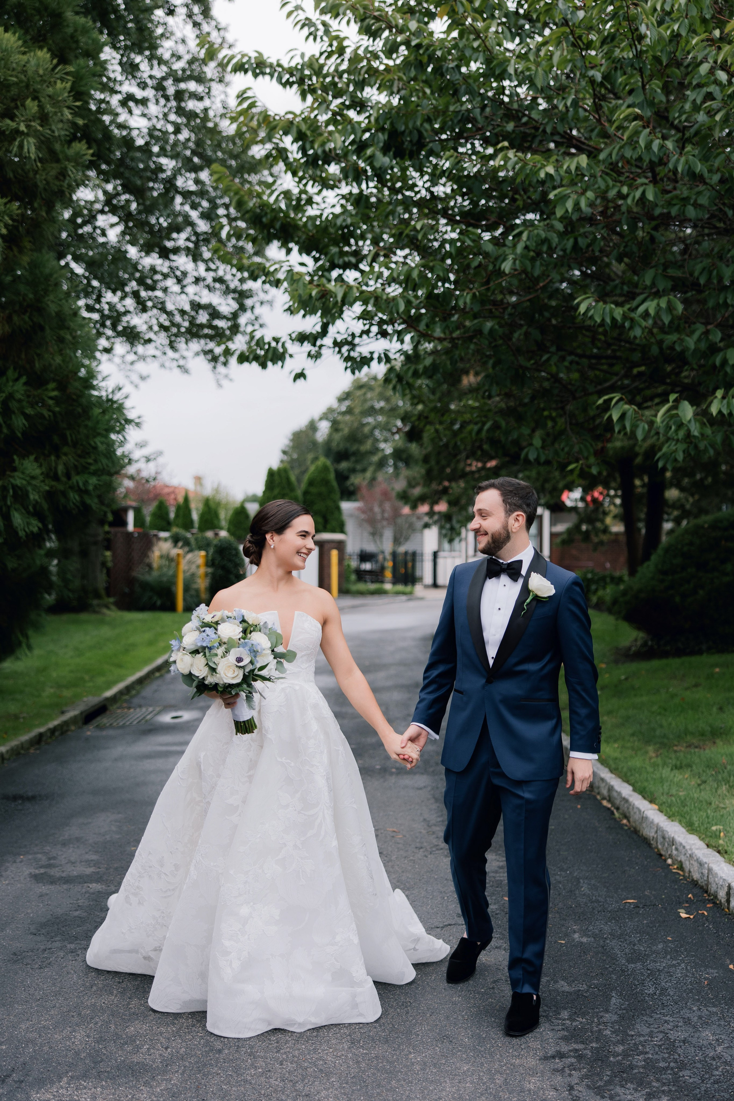 a bride and groom walking down a road