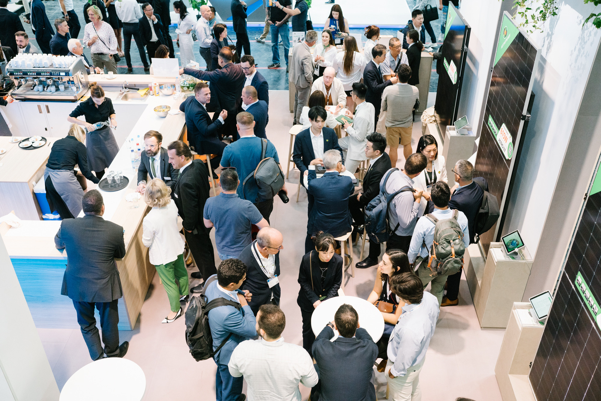 Overhead view of a crowded trade-fair stand with guests networking and exploring displays