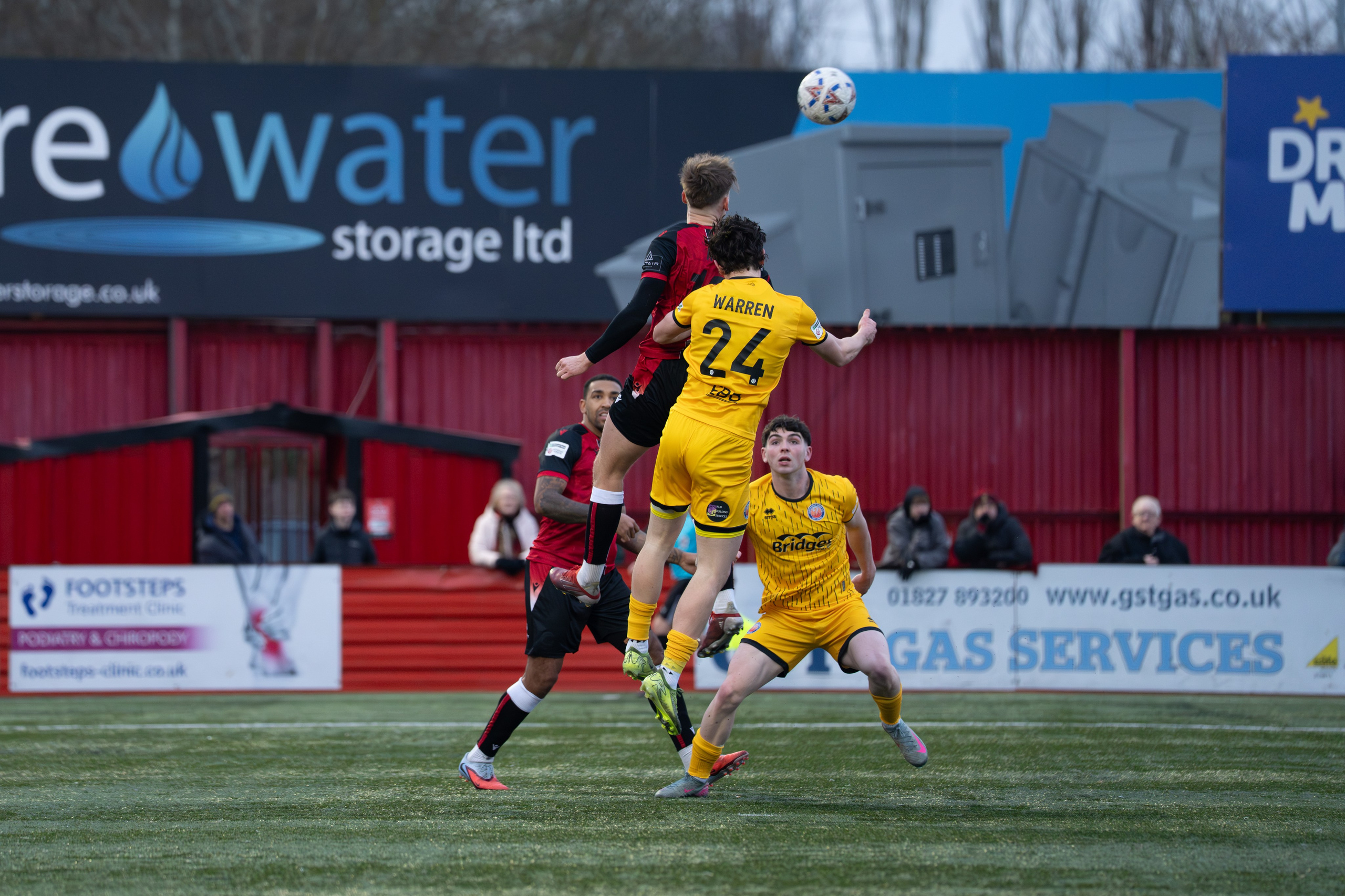 Tamworth, England — February 14, 2026: Charlie Warren of Aldershot Town challenges for a high ball with Joe Rye of Tamworth FC during the Enterprise National League match between Tamworth and Aldershot Town at The Lamb Ground. Photo: Jay Soundo
