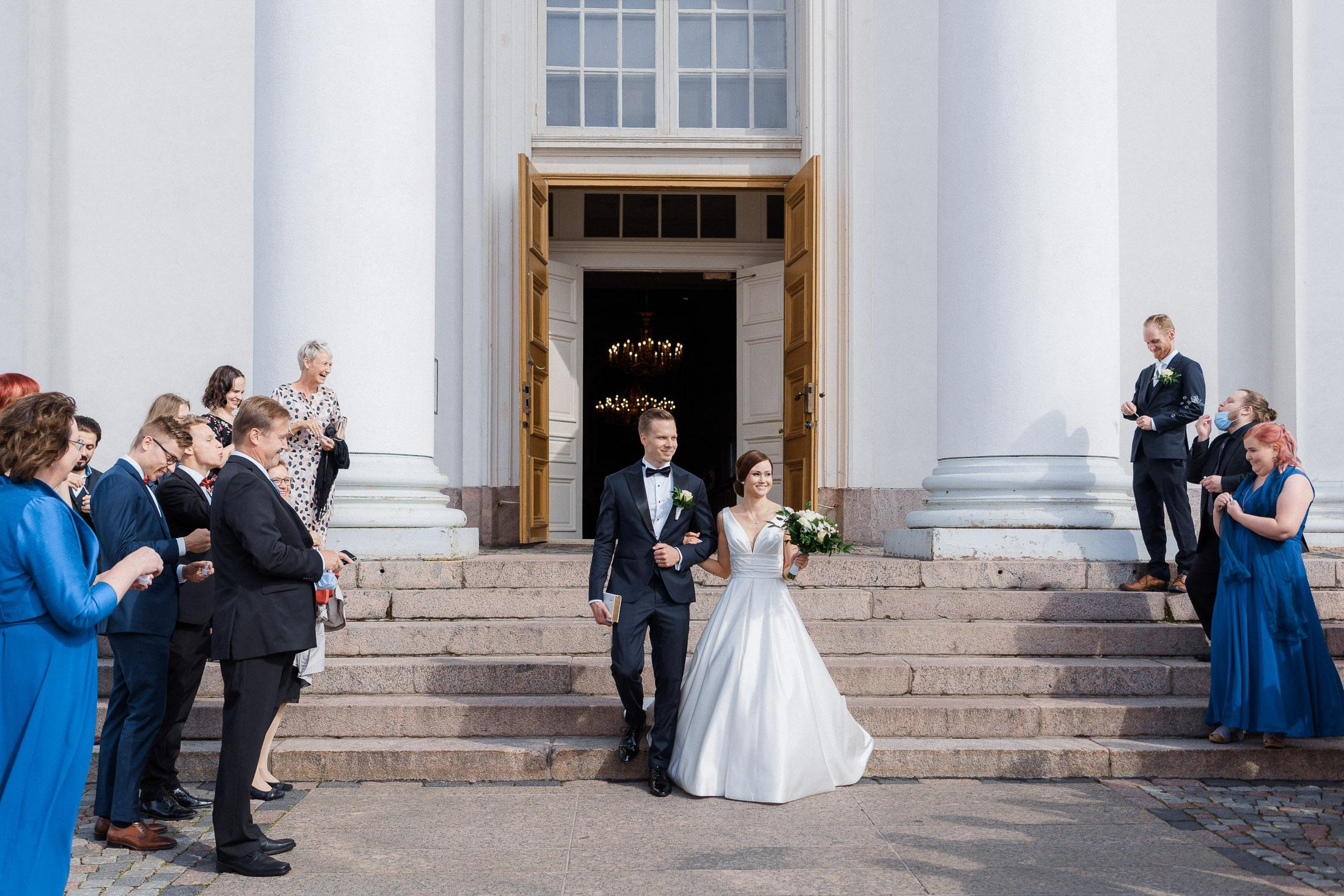 Morsian ja sulhanen astuvat ulos Helsingin tuomion kirkosta