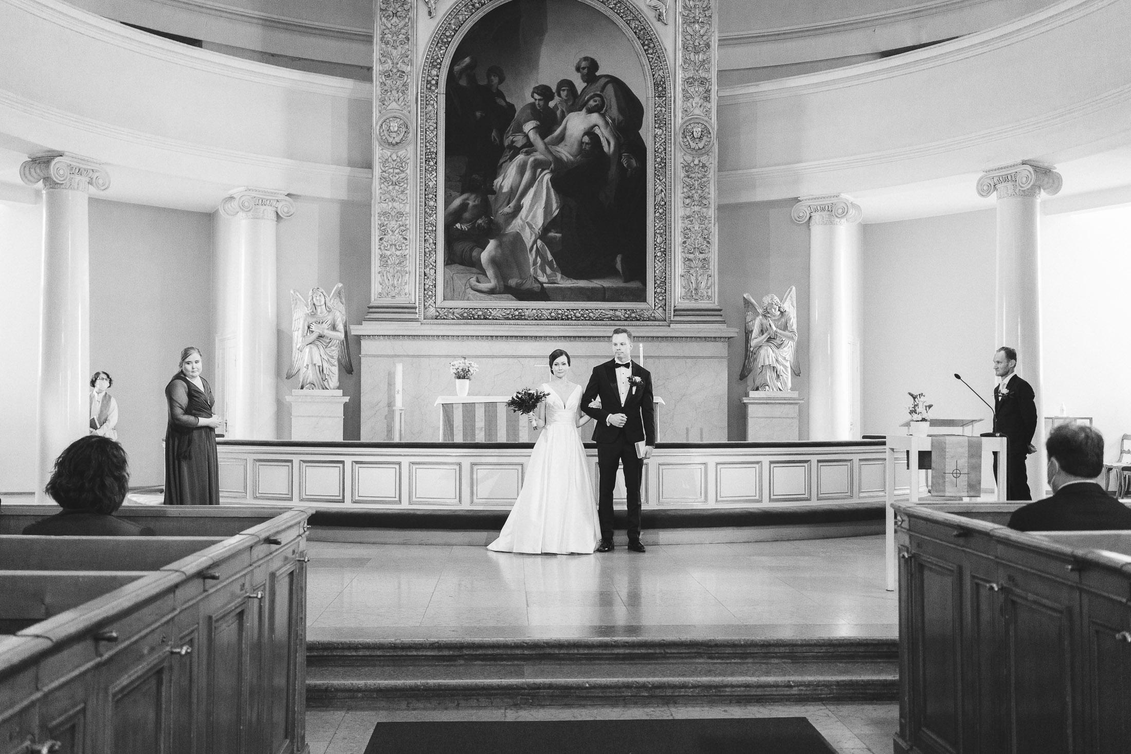 Morsian ja sulhanen kävelevät alttarilta Helsingin tuomion kirkossa