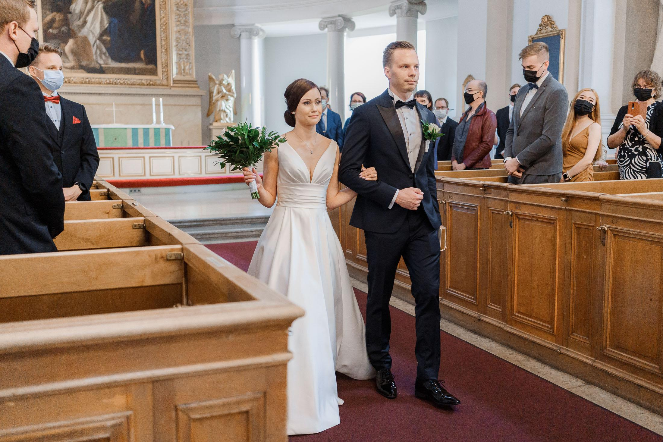 Morsian ja sulhanen kävelevät alttarilta Helsinginntuomion kirkossa