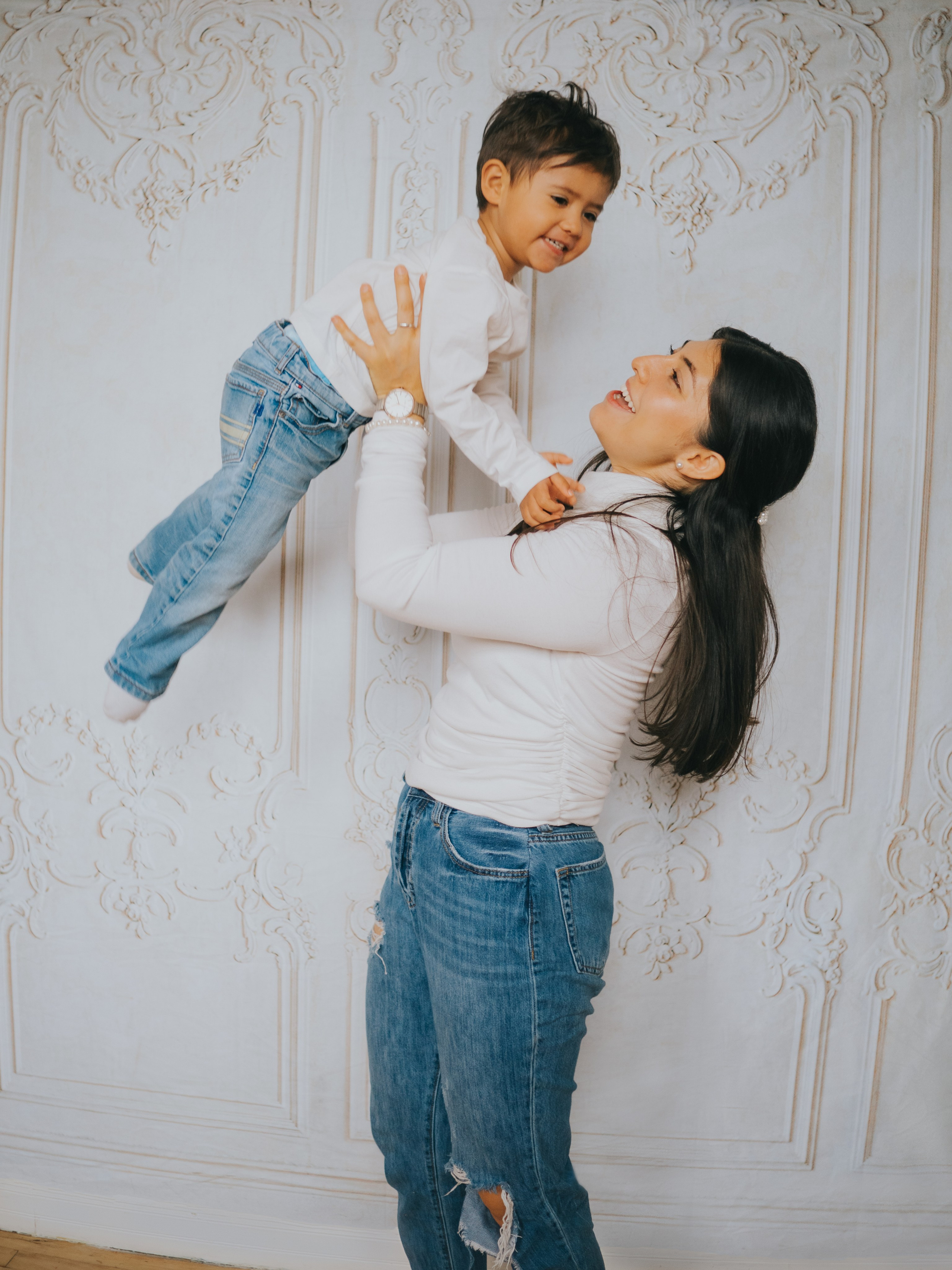 La mère balance son fils dans les airs.
