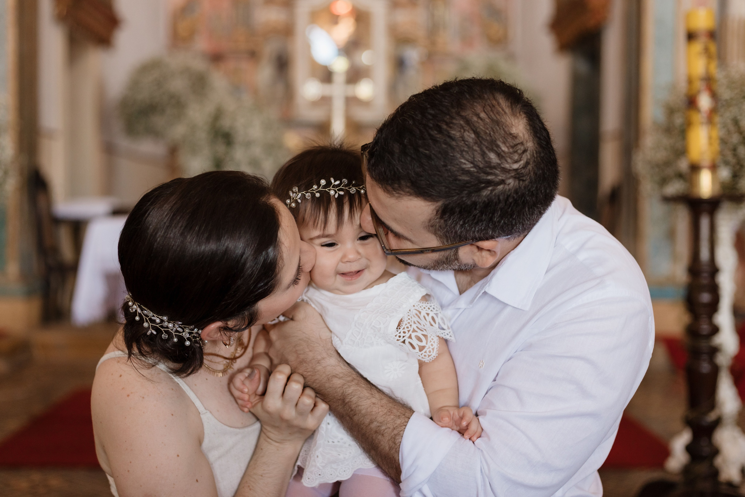Pais com a bebê antes da cerimônia de batizado