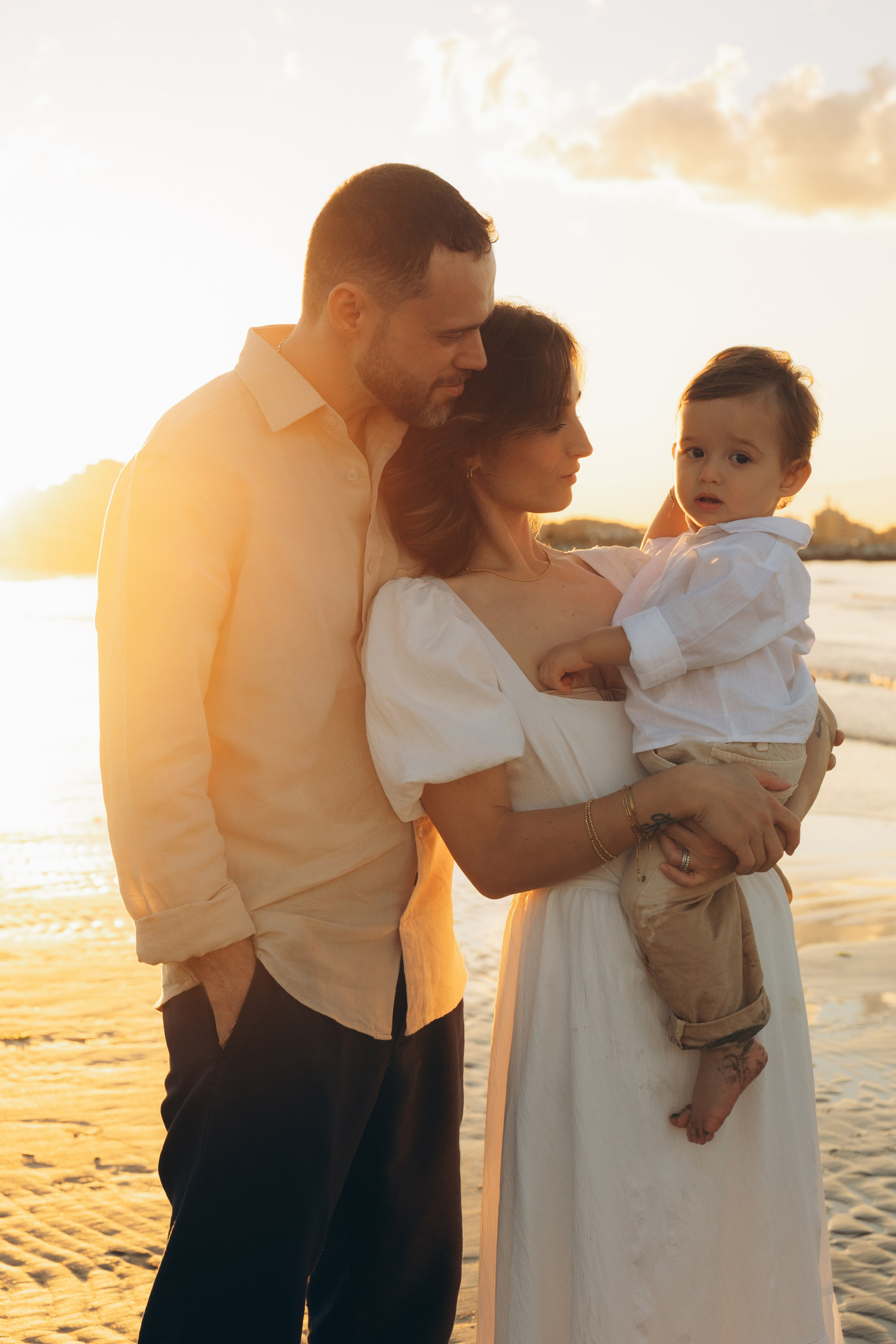 genitori con bambino in braccio durante un servizio fotografico di famiglia a Rimini
