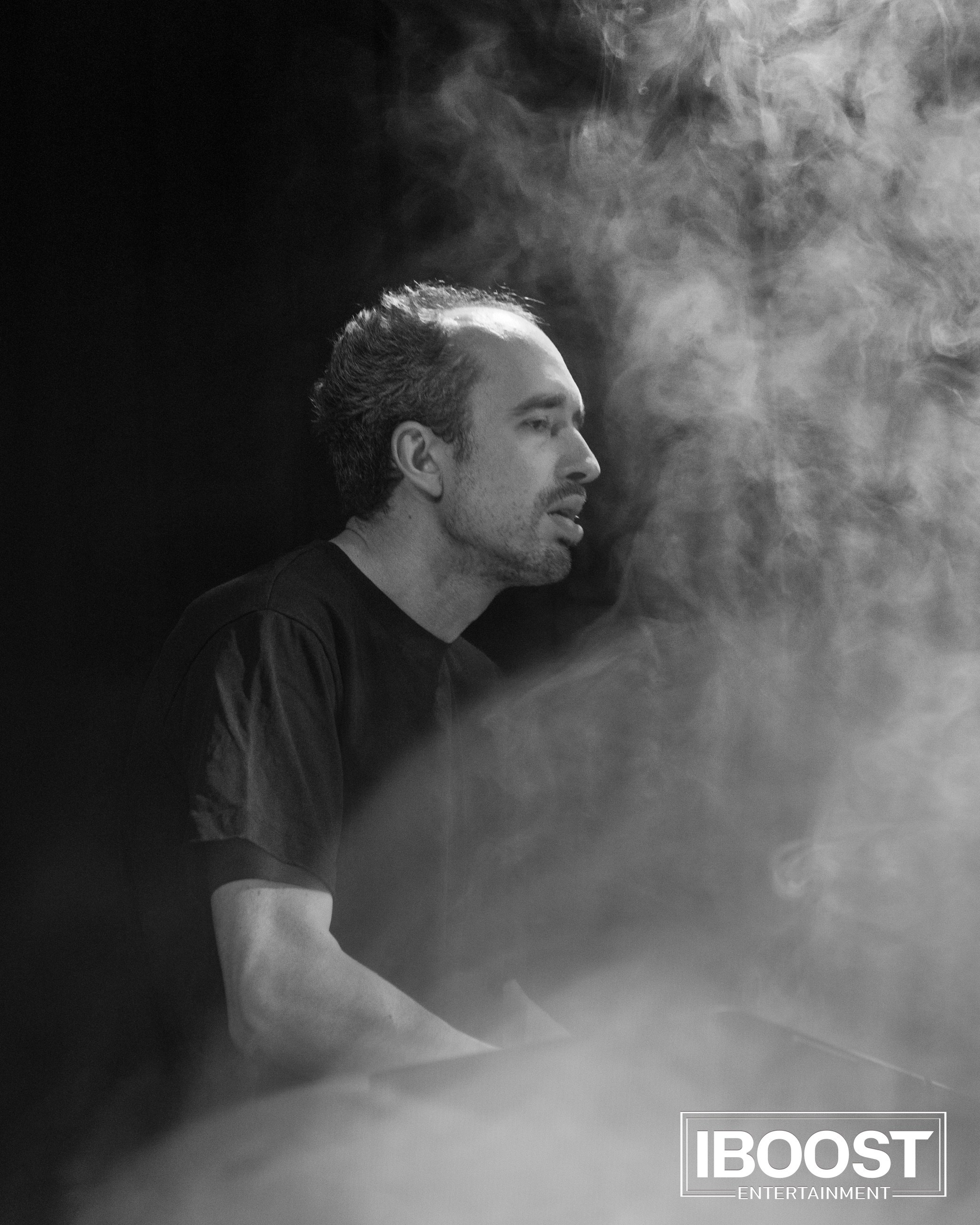 Black-and-white portrait of the Animal JazZ keyboardist on stage in Sofia surrounded by smoke.