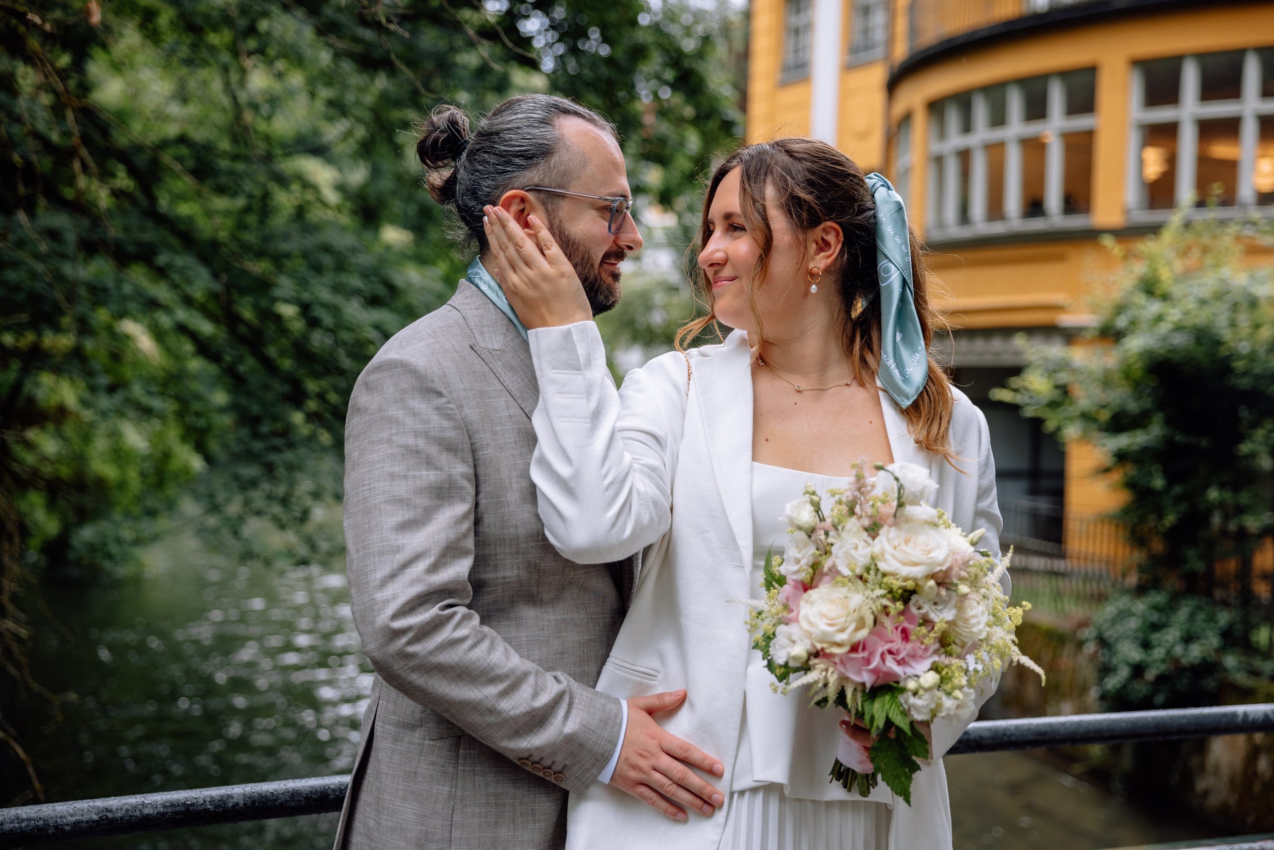 Braut berührt Gesicht des Bräutigams – romantischer Moment vor Standesamt Schwabing