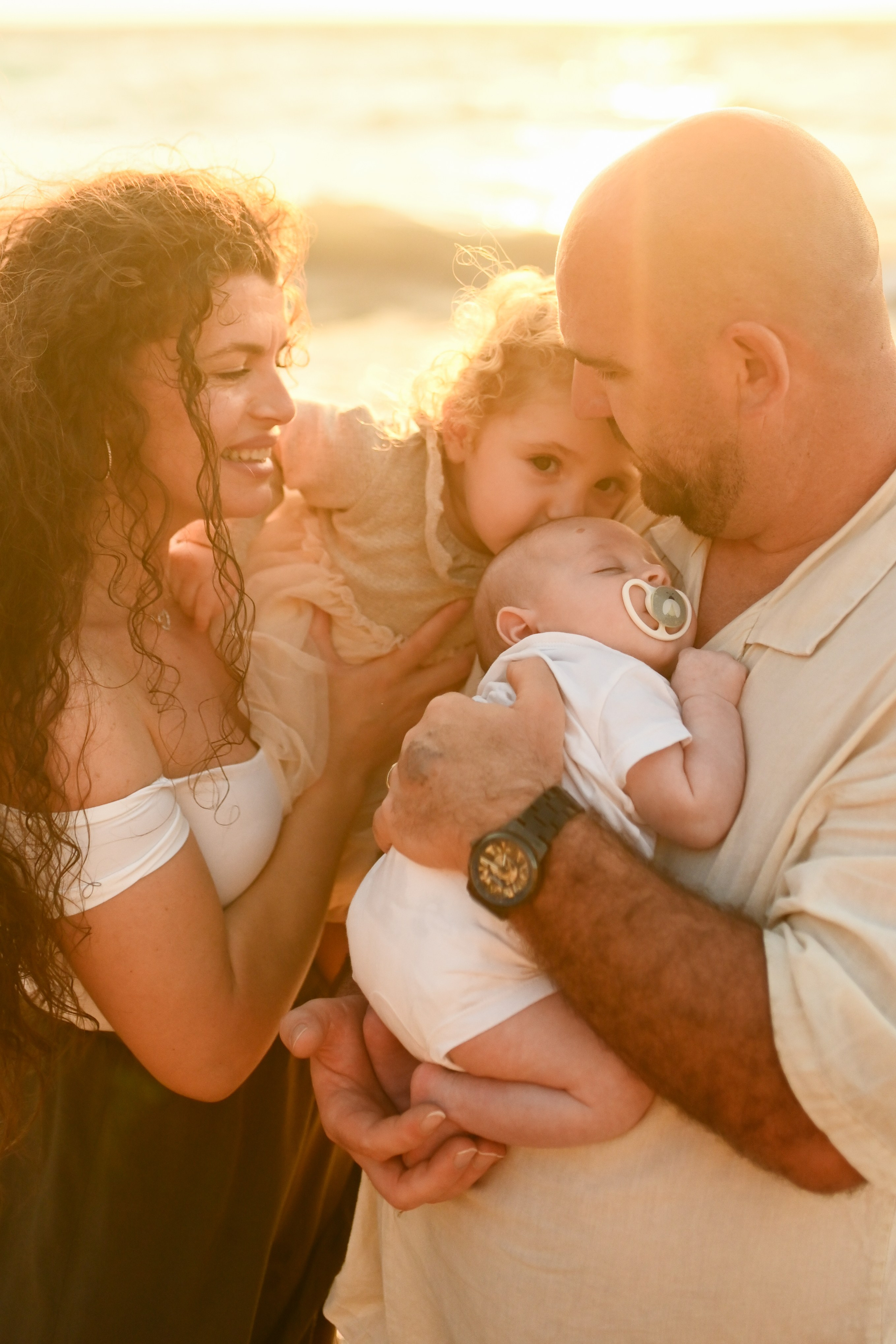 Happy family walking along a Rhodes beach at sunset. Photographer in Rhodes Island