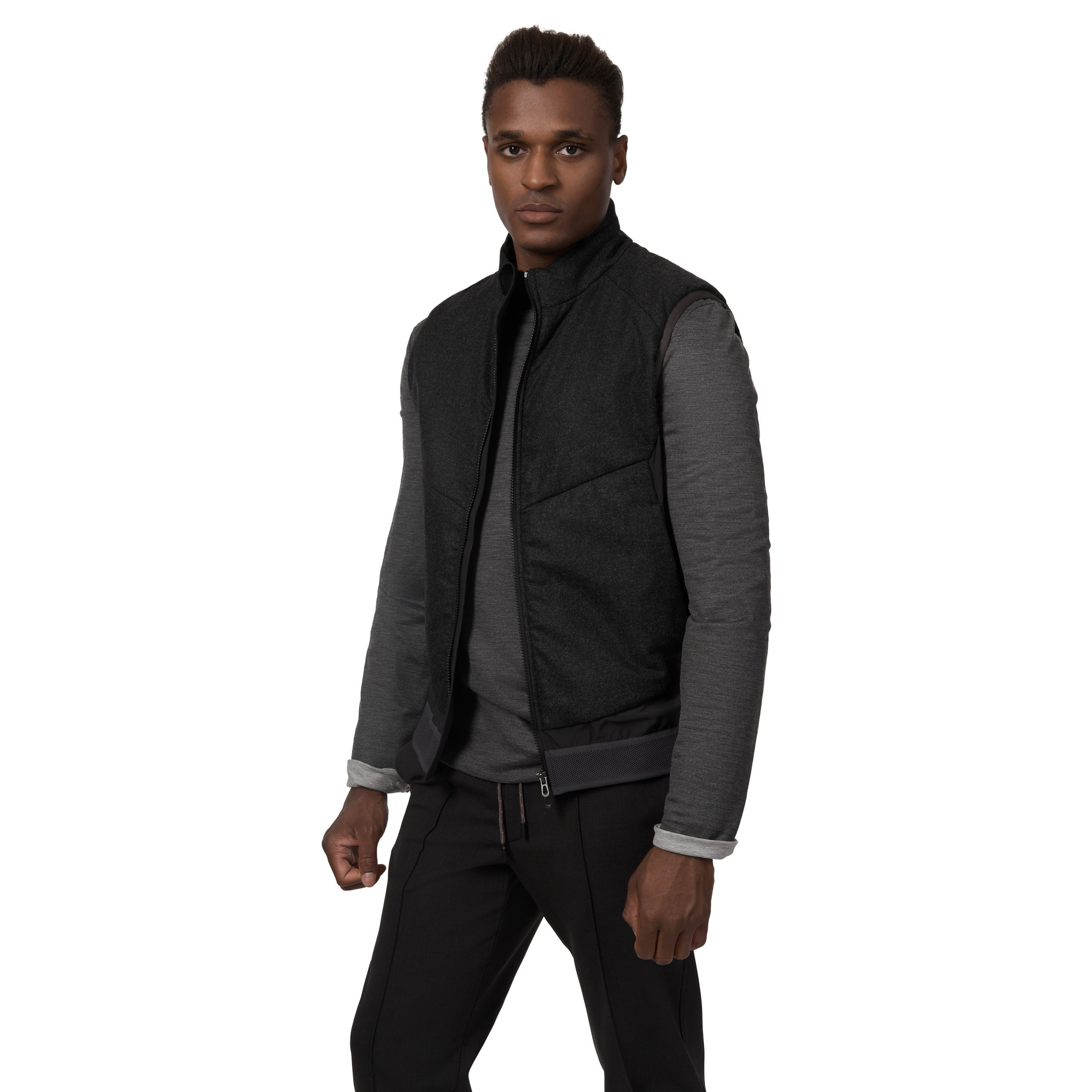 Model in grauer Jacke mit schwarzem Kragen, lässige Pose, Studioaufnahme.