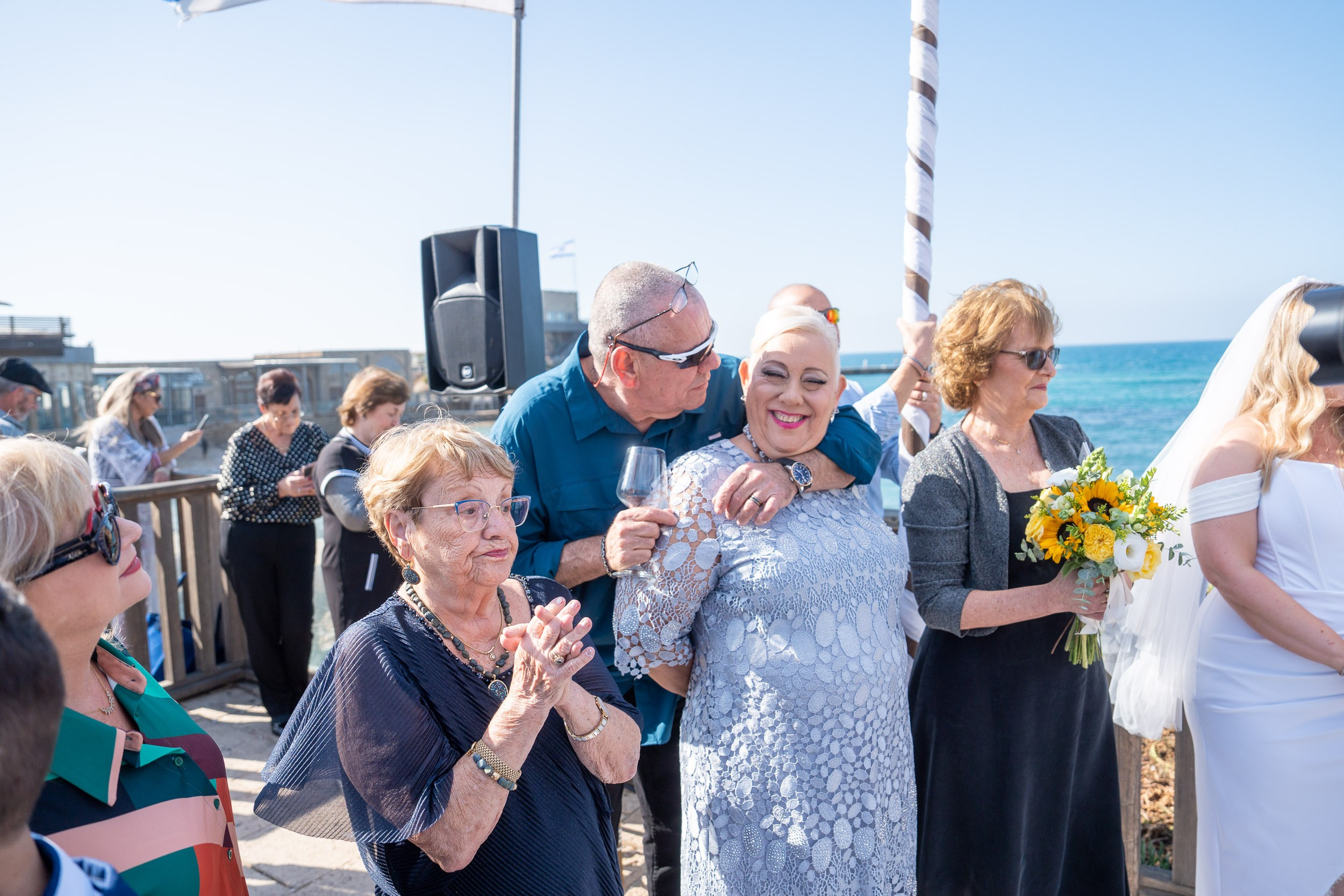 Family members embrace as they watch the wedding ceremony