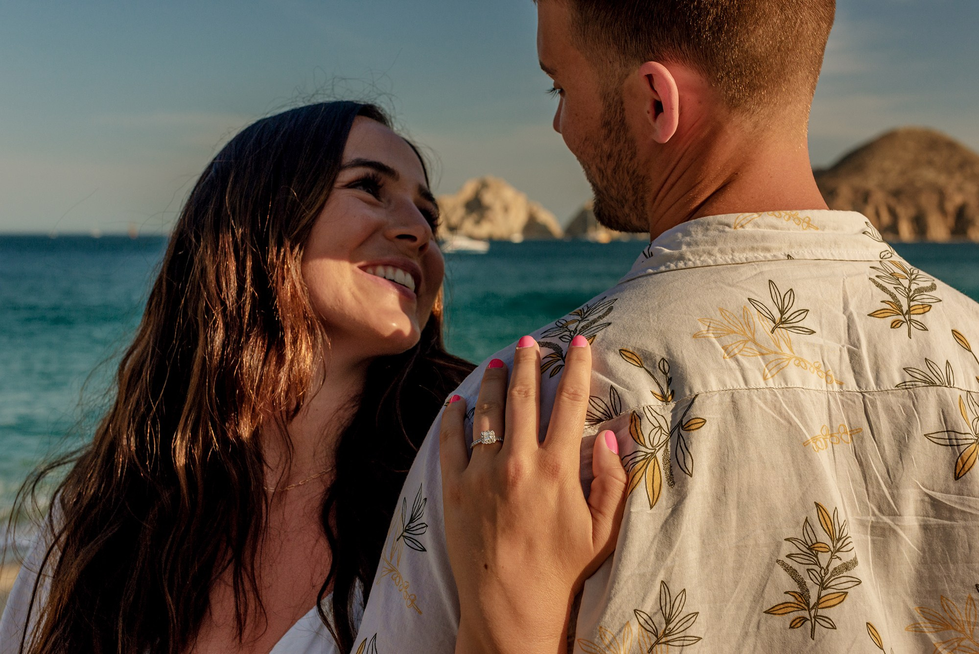 Couple hugging after surprise proposal in Los Cabos Mexico