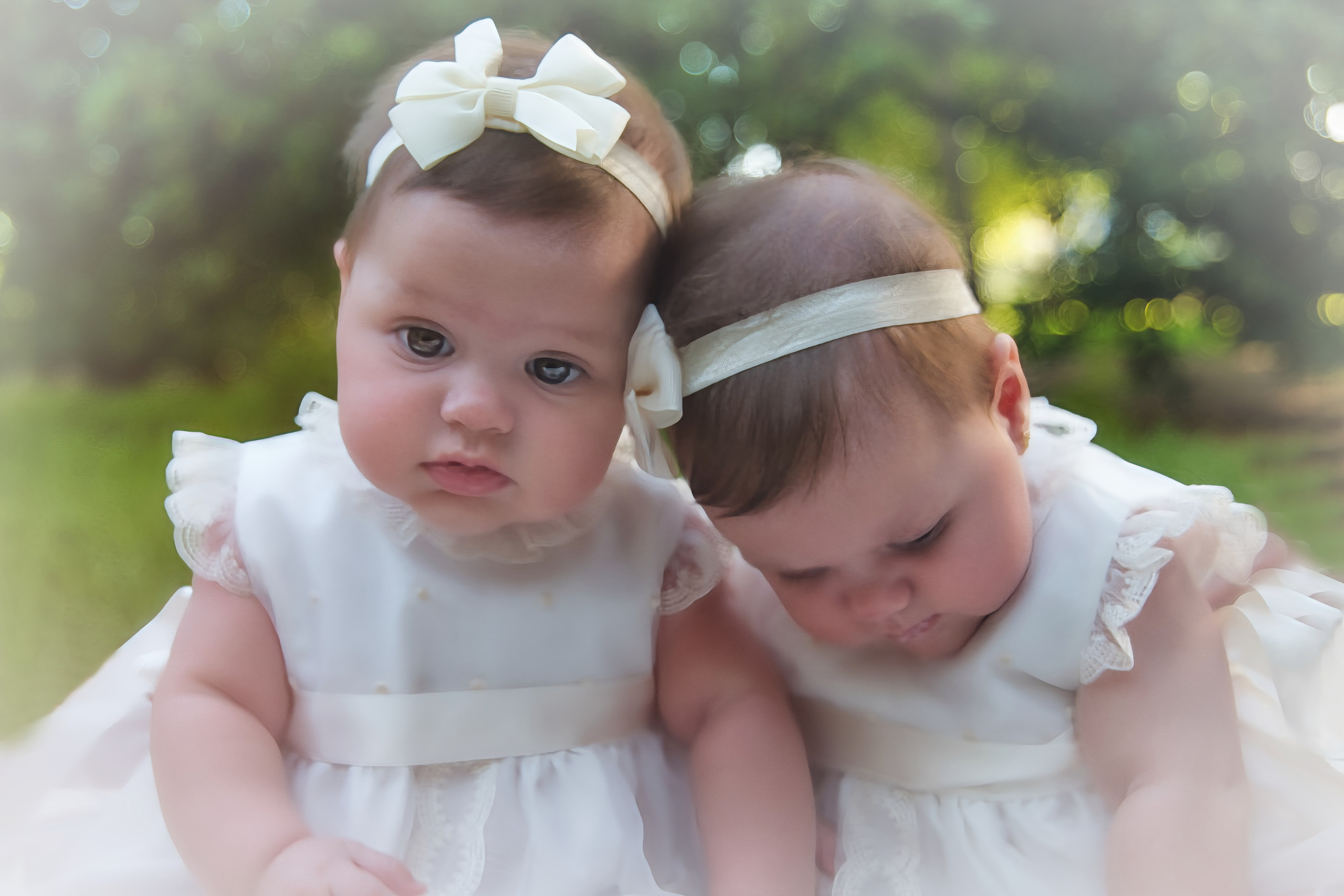 Niña vestida con traje de bautizo blanco, sostenida por sus padres en la iglesia.