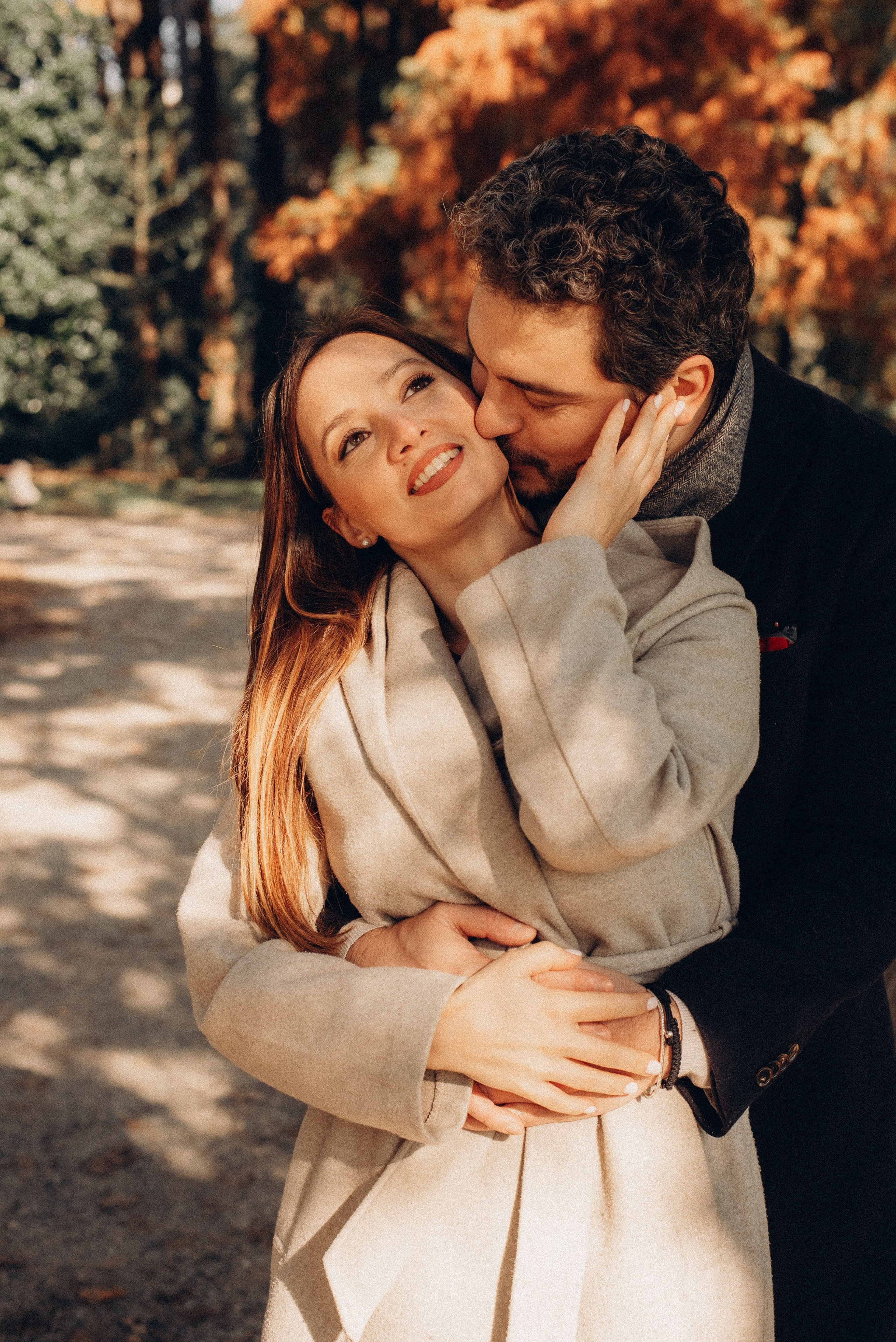 Happy couple hugging in the autumn park during a love story photoshoot in Milan. Milan love story photographer. Proposal photoshoot Milan