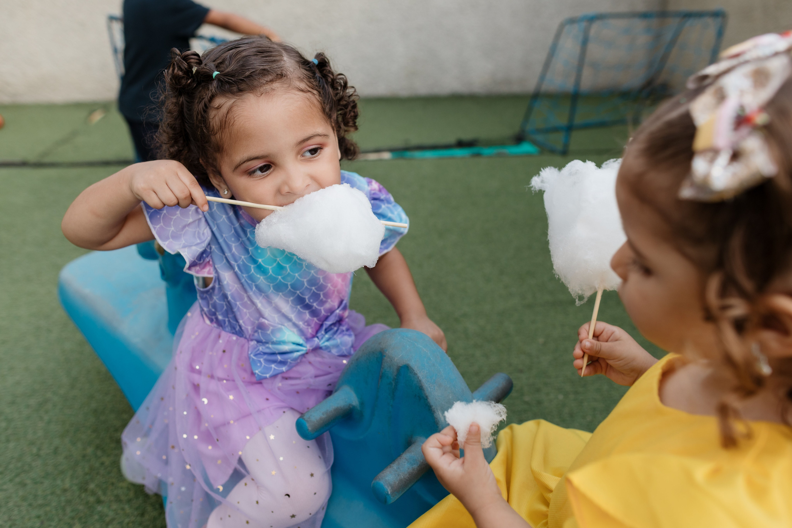 Crianças brincando em parquinho com algodão doce