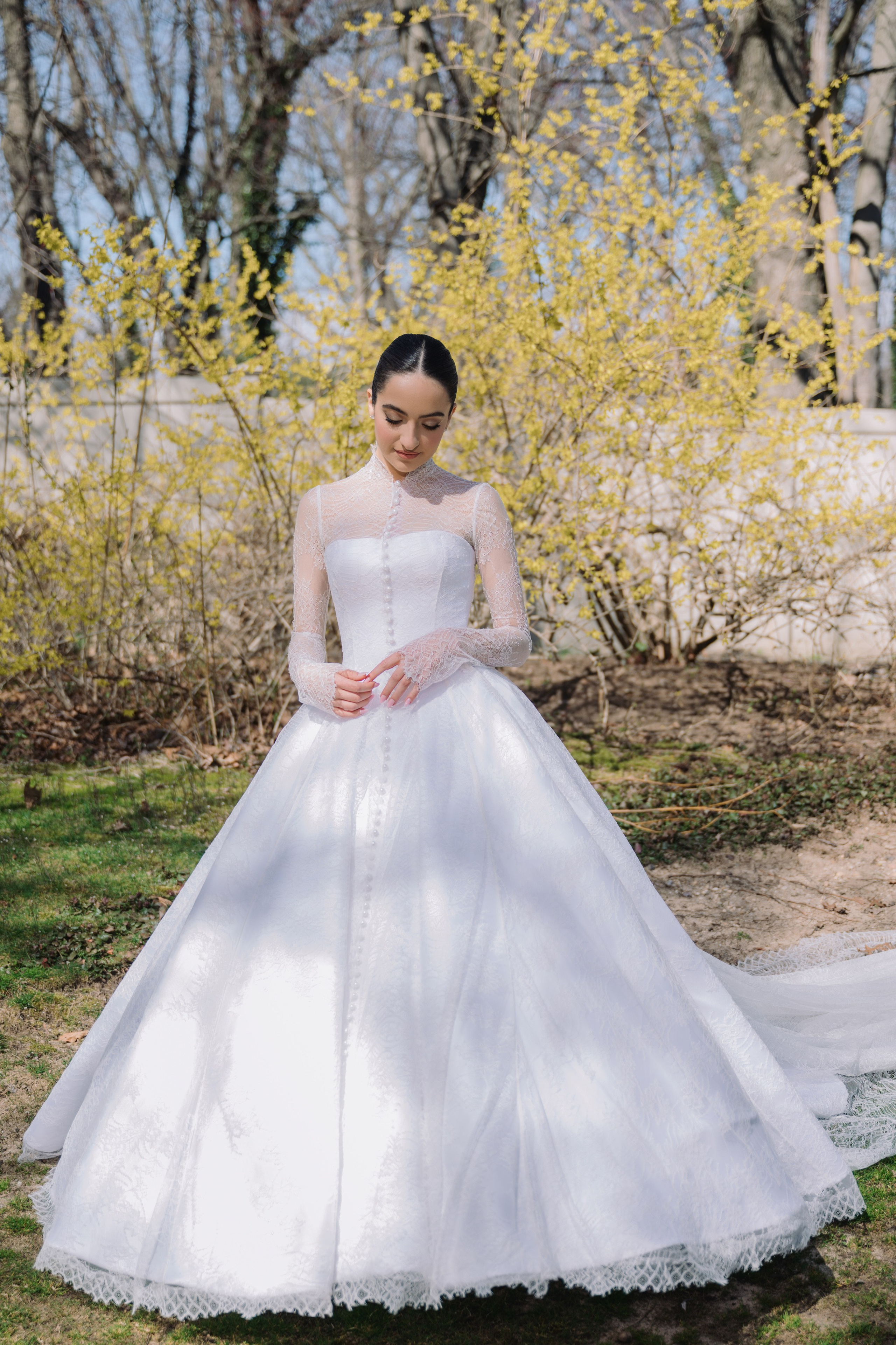 a bride in a white wedding dress standing in the grass