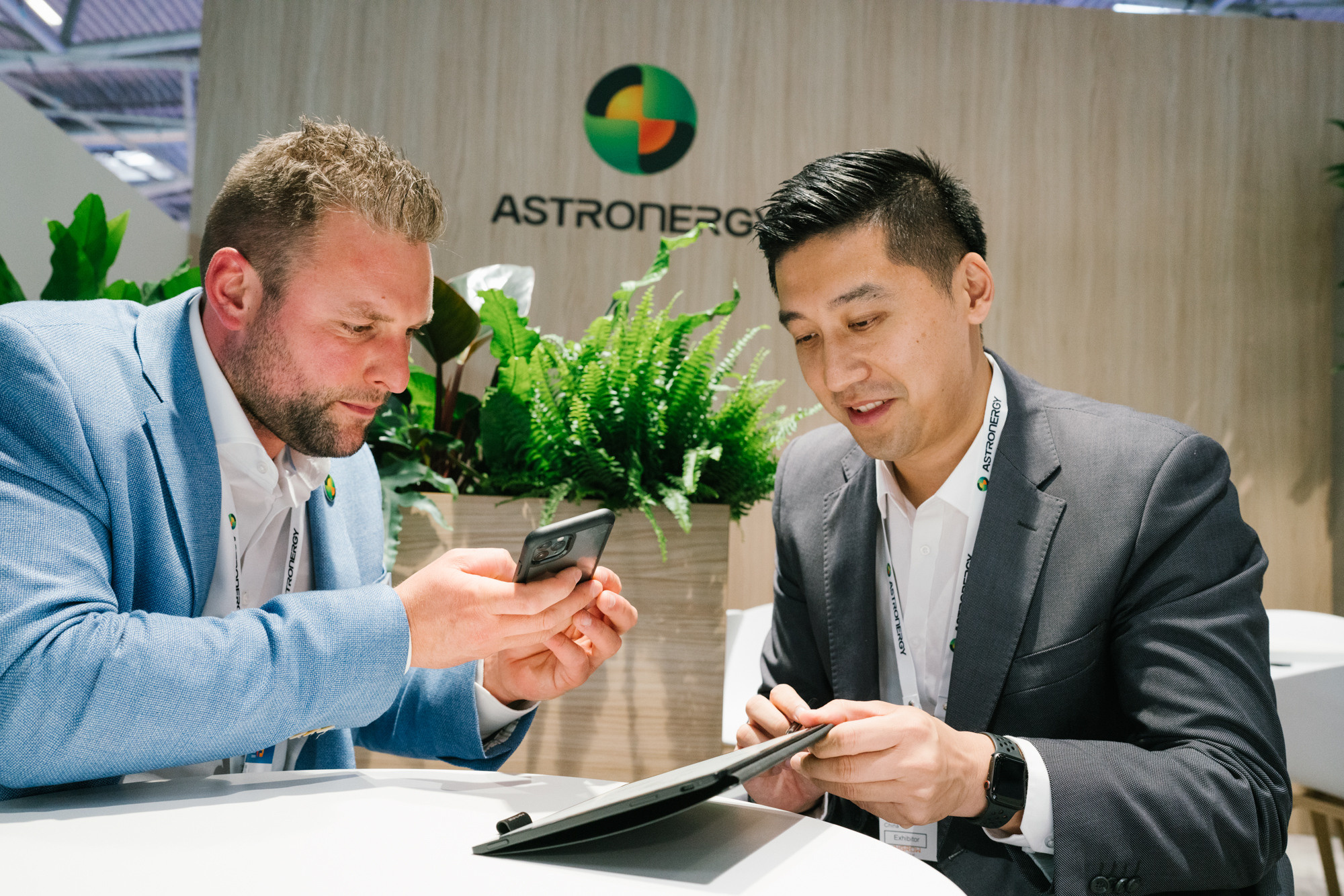 Two businessmen reviewing documents at a trade-fair meeting table