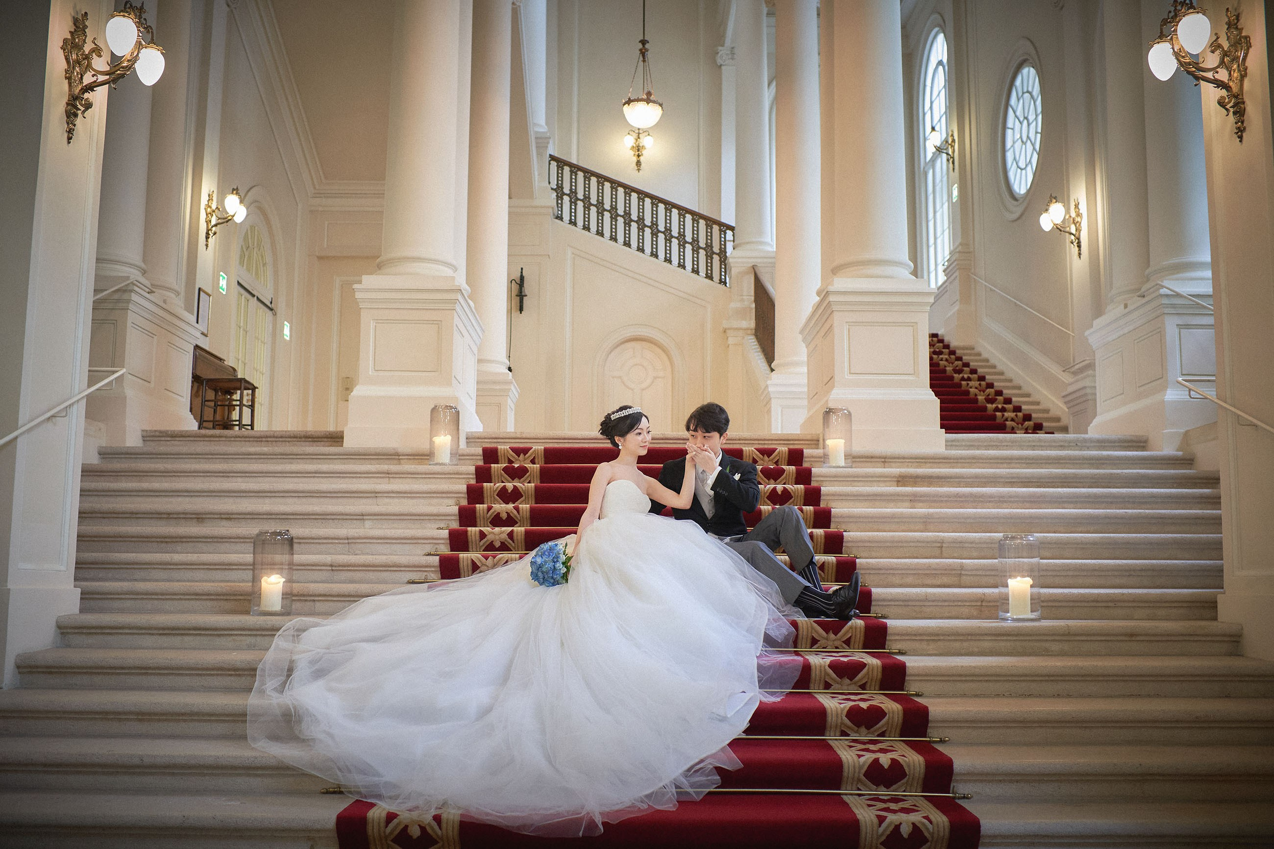 A final portrait of the bride and groom atop the red carpet inside the Palais Coburg.