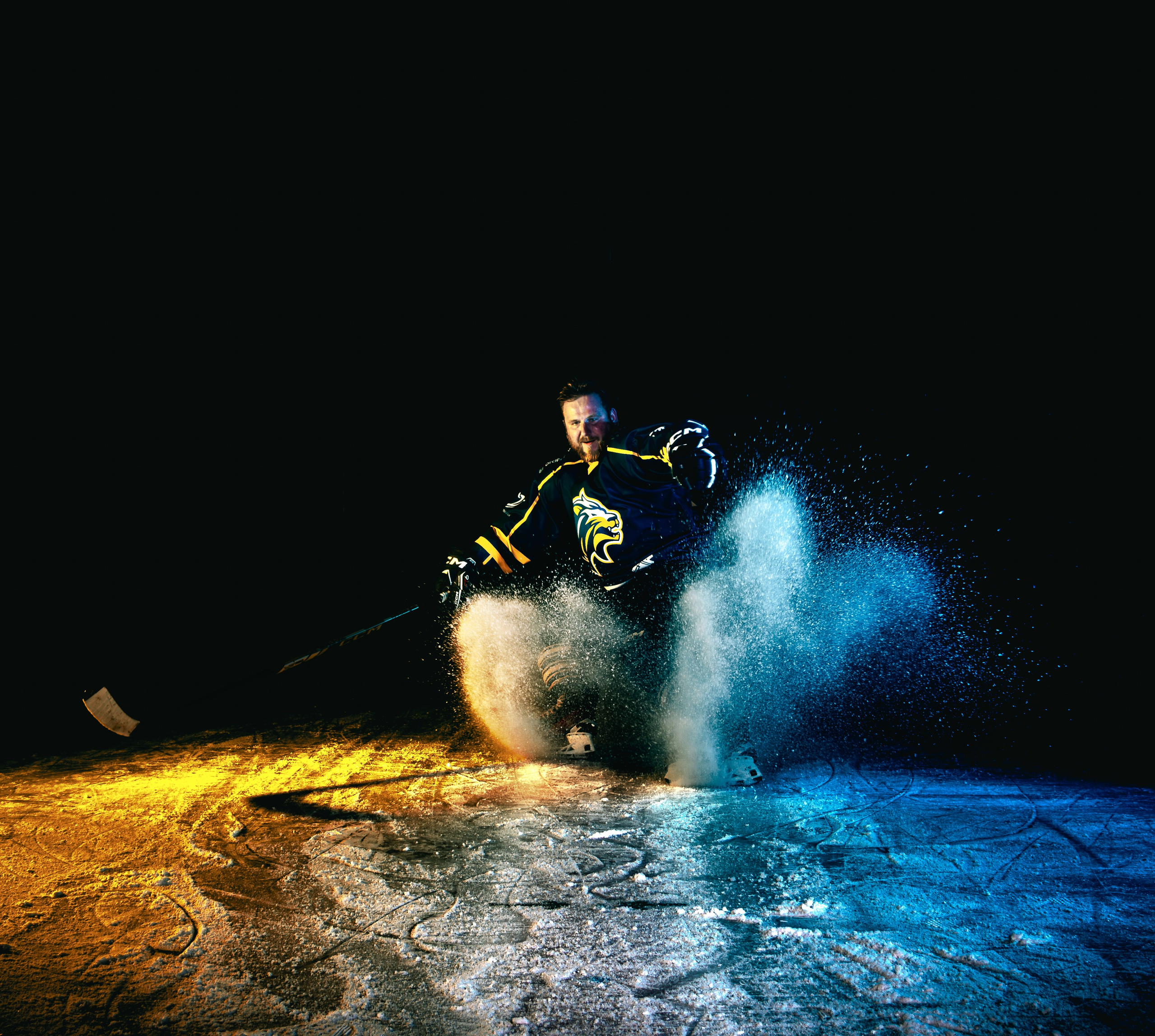 Speler poseert met stick onder fel spotlicht en rooksluier