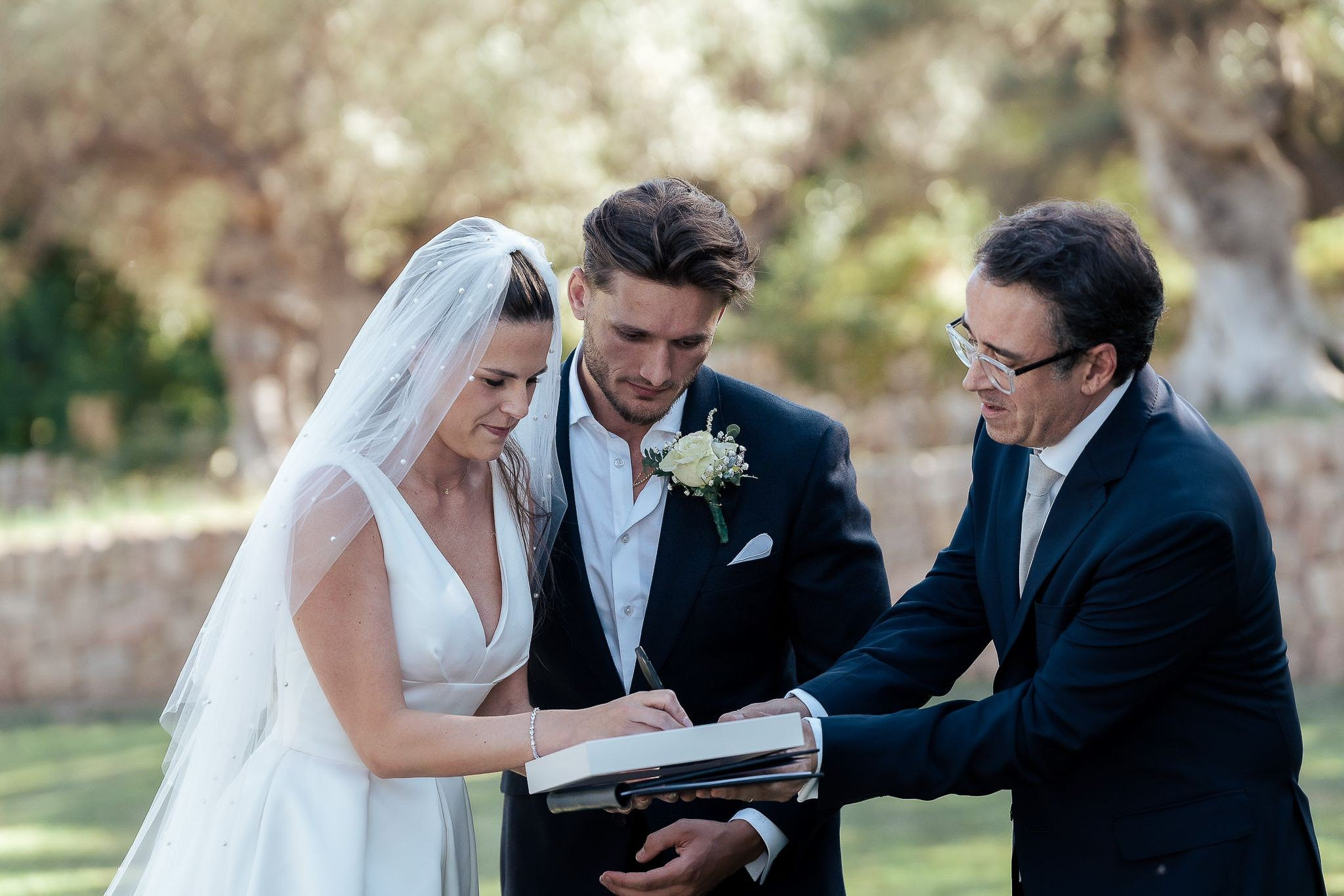 Bride and groom signing the ceremony register with their wedding celebrant in Mallorca