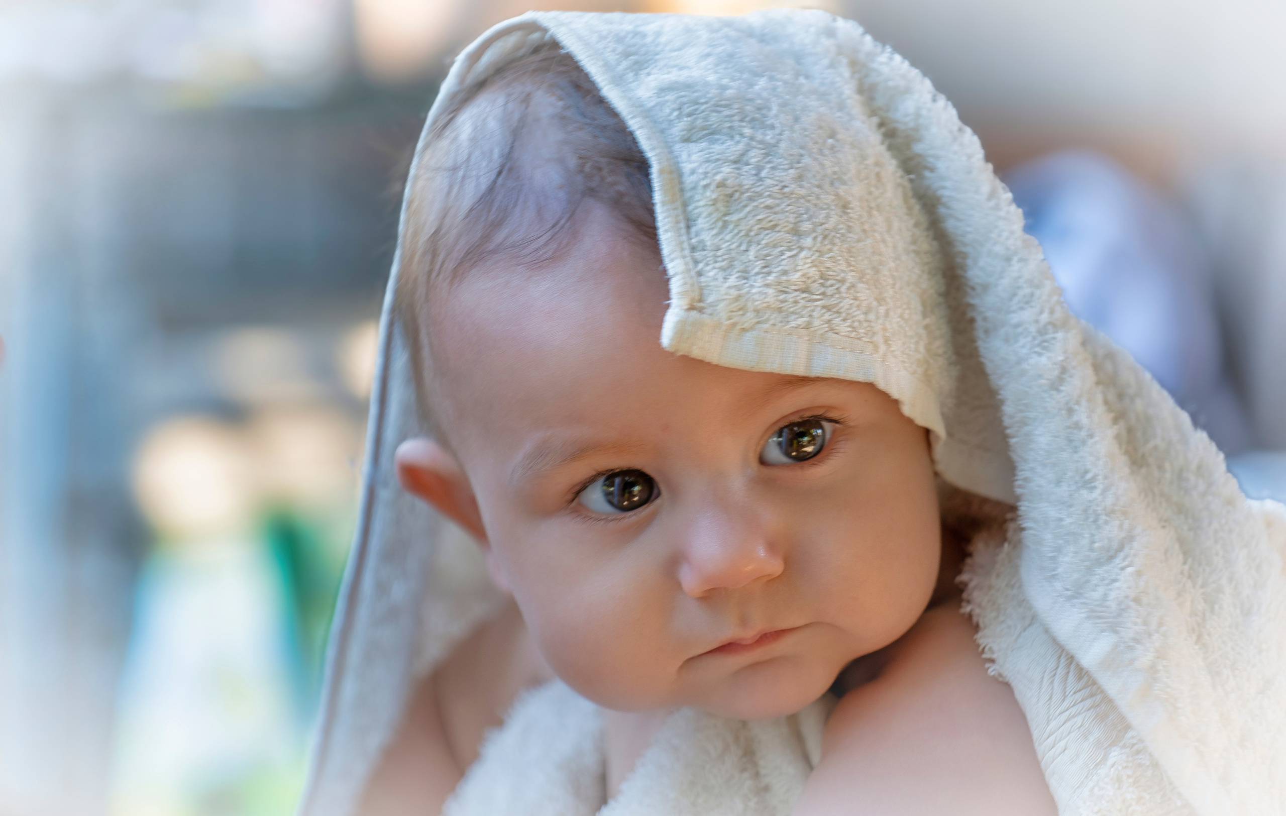 Bebé envuelto en una toalla blanca después del baño.