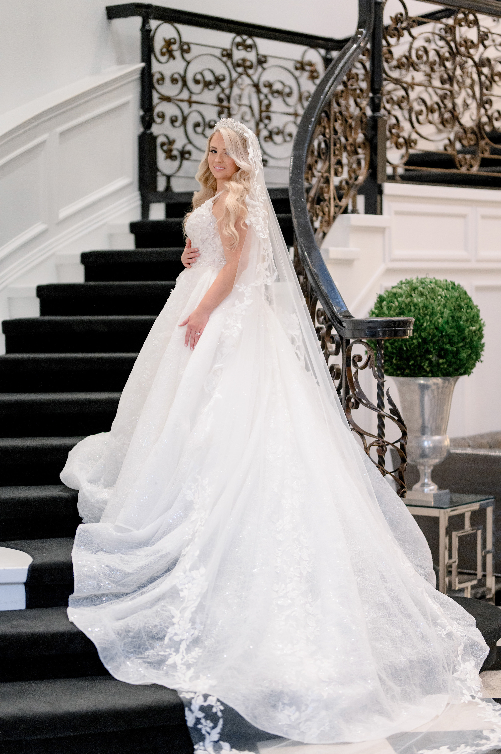 a bride in a wedding dress standing on the stairs