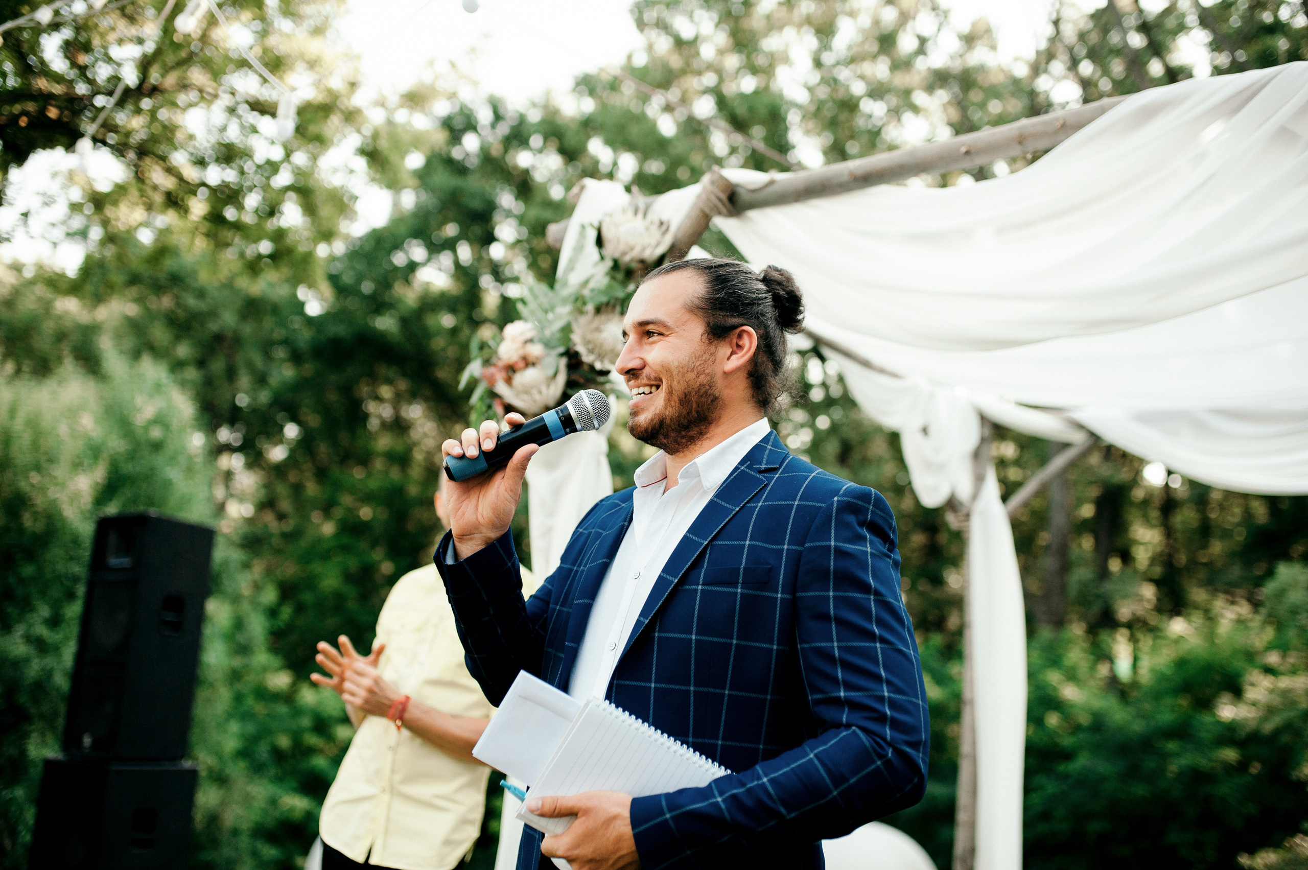 a man in a suit and tie holding a microphone