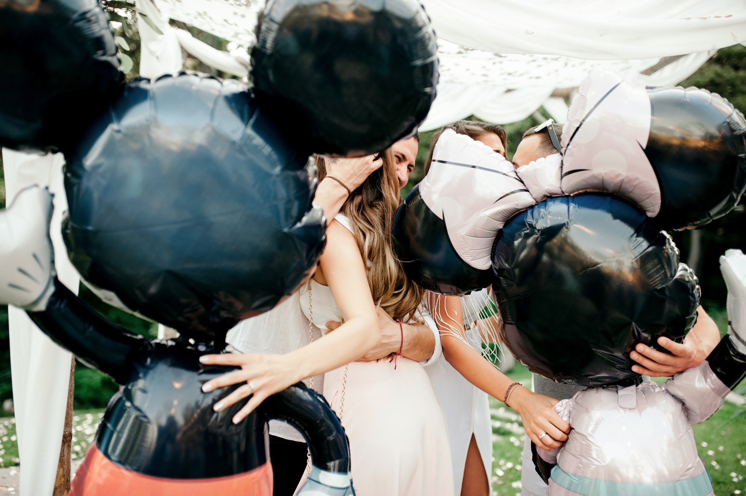 a group of people standing around a bunch of balloons
